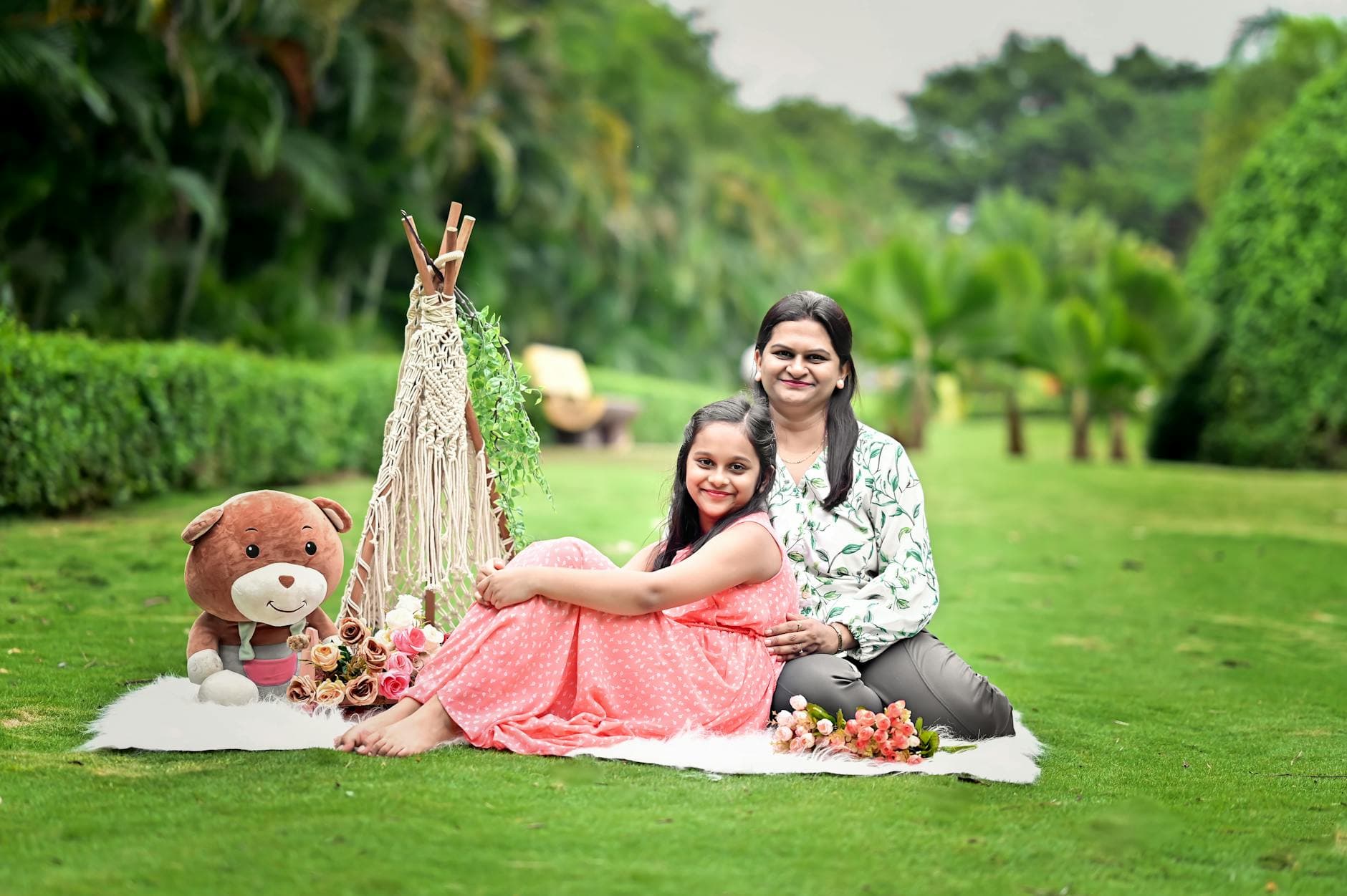 A joyful mother and daughter enjoy a picnic setting in a vibrant green garden. - anger management near me