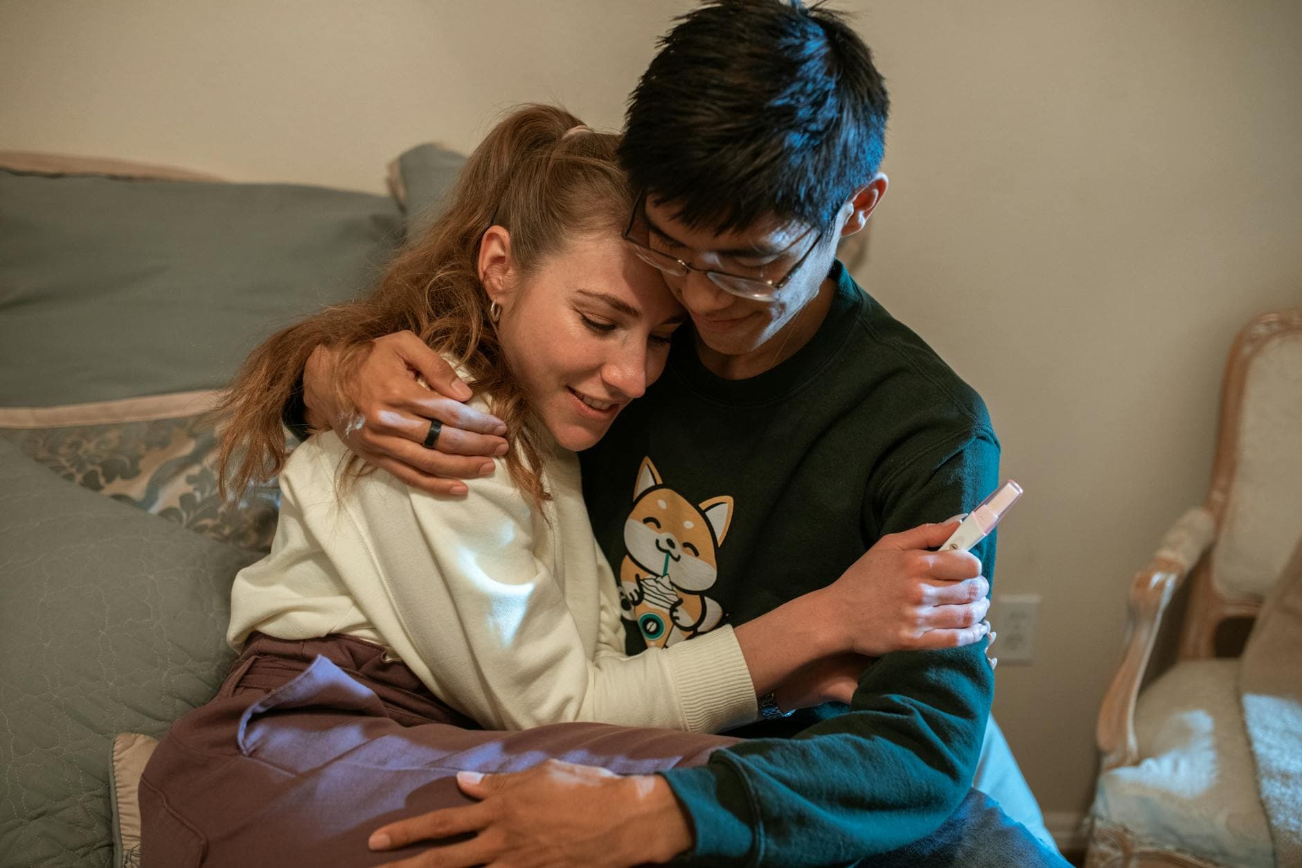 A happy couple hugging with a pregnancy test in hand, celebrating new beginnings indoors. - fear of commitment new relationship