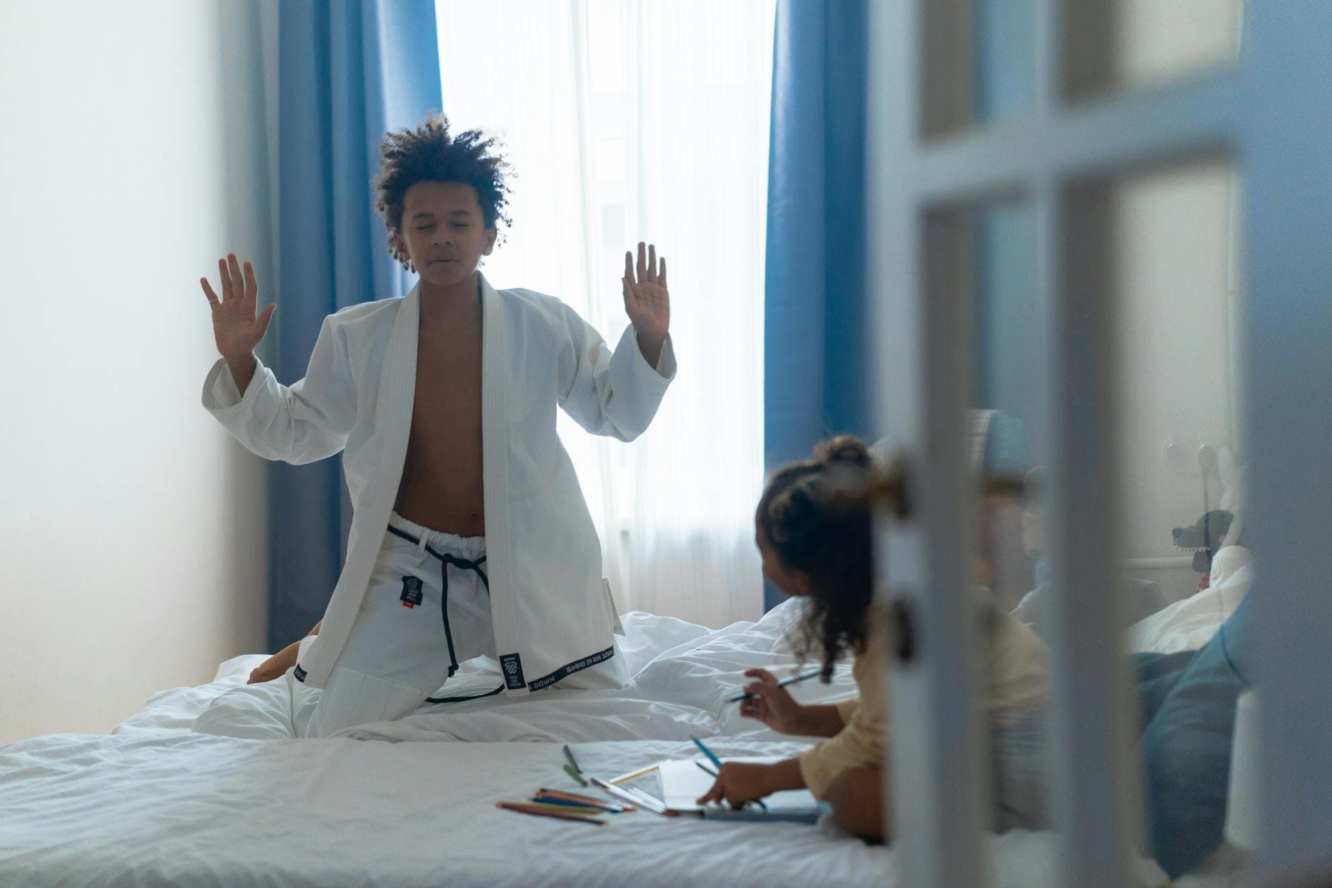 Teen practicing martial arts in bedroom wearing white gi, creating a serene scene with natural light. - improving teen communication at home