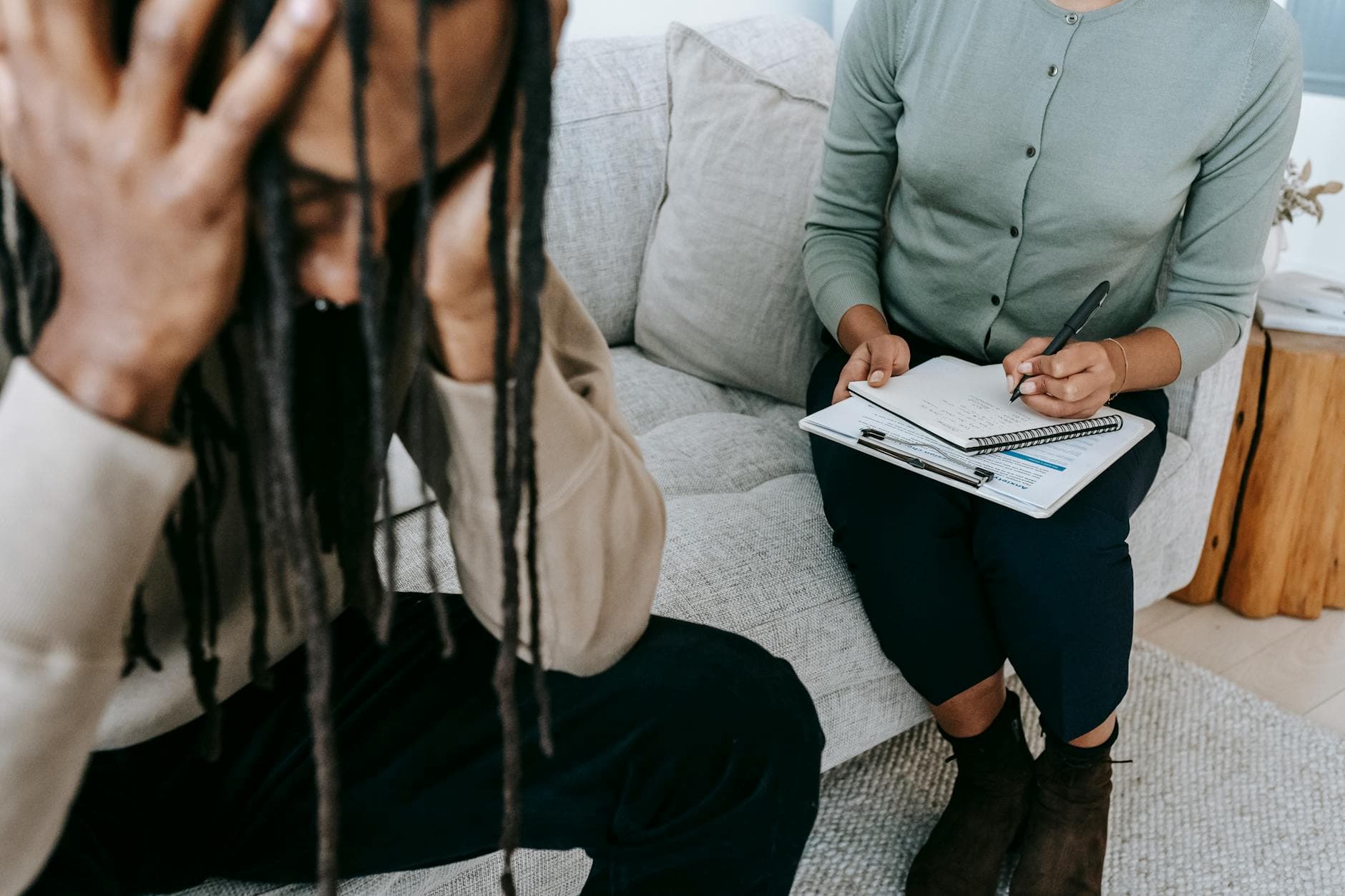 A therapy session showing a concerned patient and a therapist taking notes. - mindfulness for winter anxiety