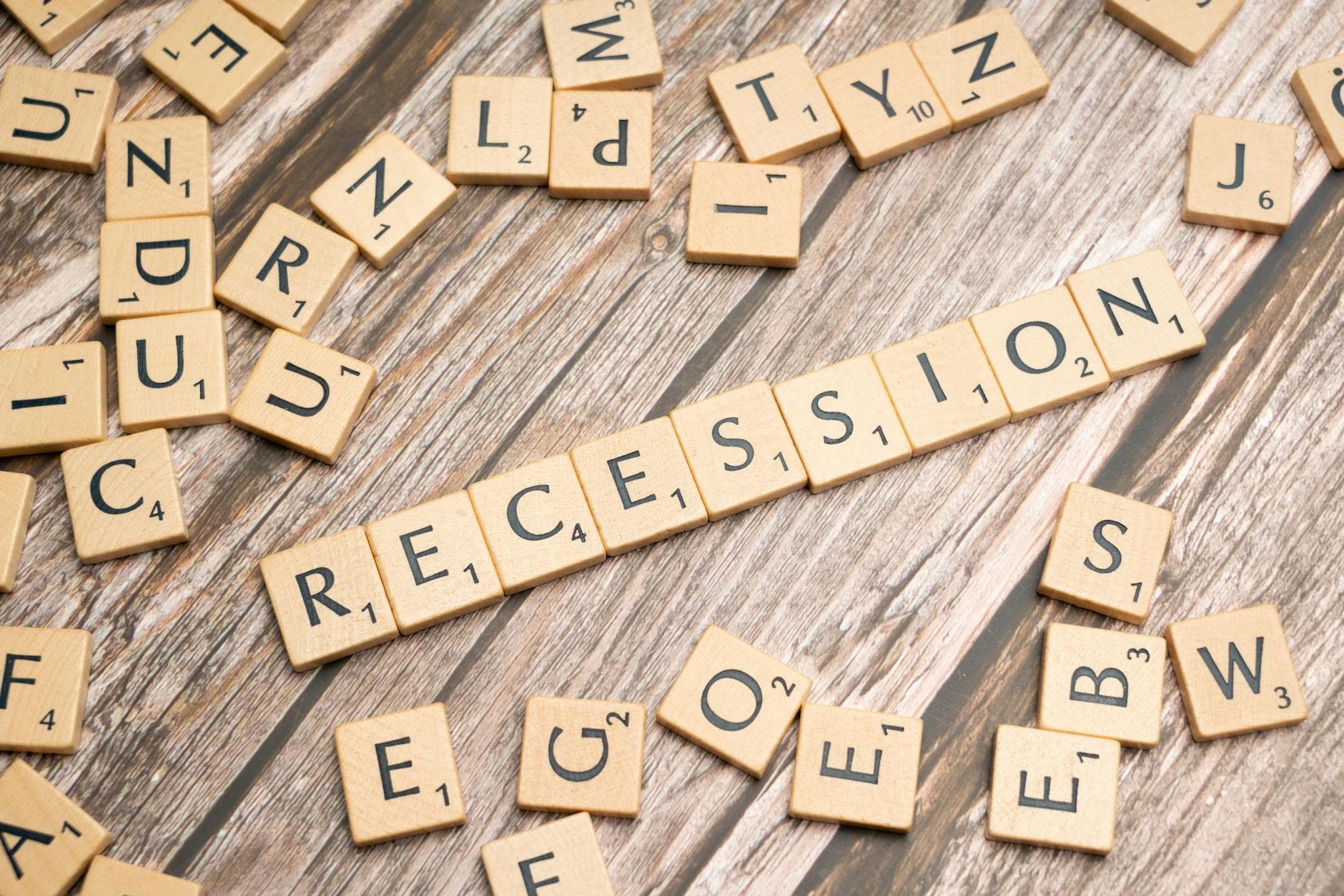 Wooden letter tiles on a wooden surface spell out the word "Recession," symbolizing economic downturn. - therapy for winter slump