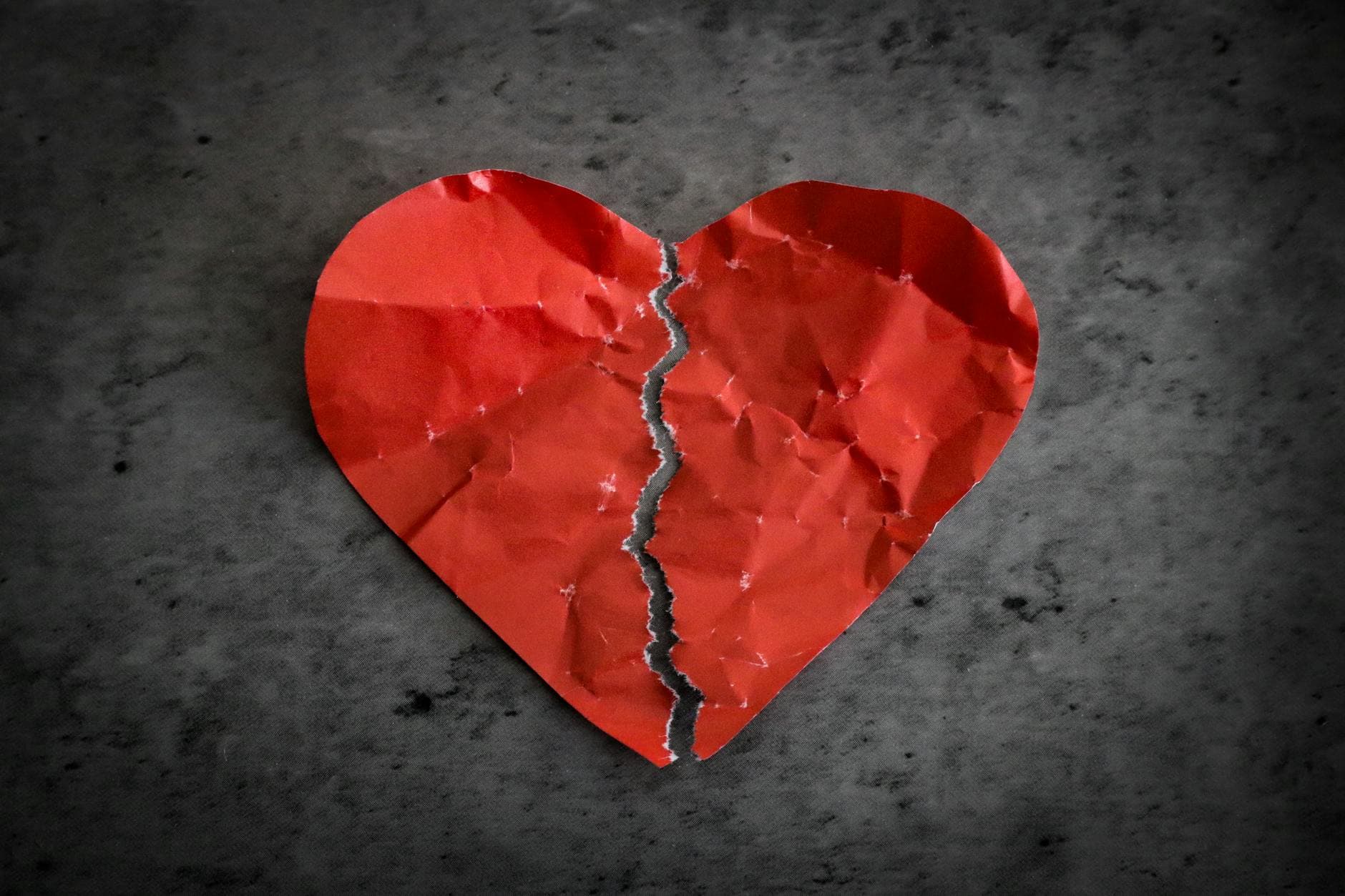 A torn red paper heart symbolizing heartbreak and lost romance. - valentine's day divorce parenting