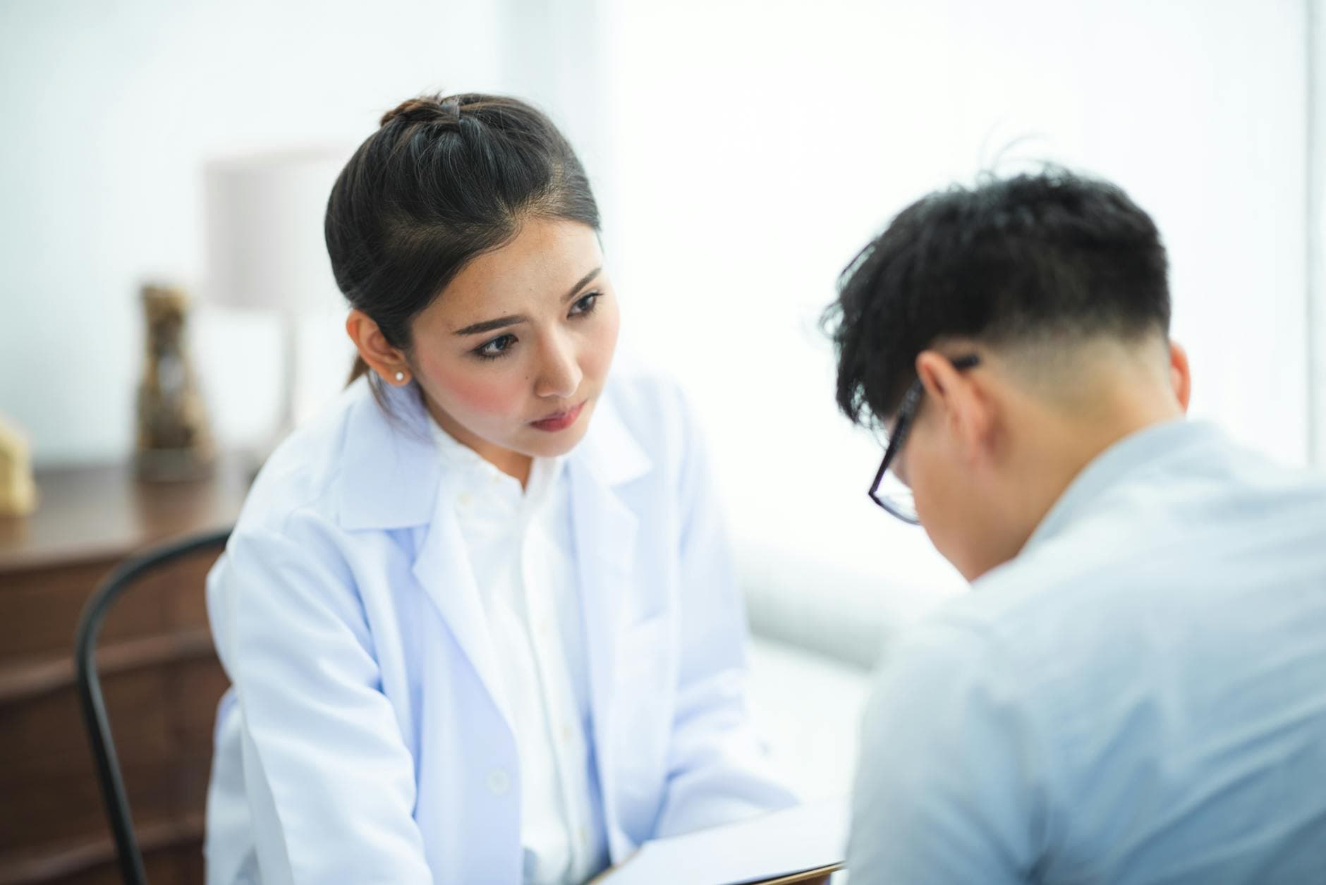 A doctor attentively listens to a patient during a medical consultation, emphasizing care and understanding. - winter mental health gut health
