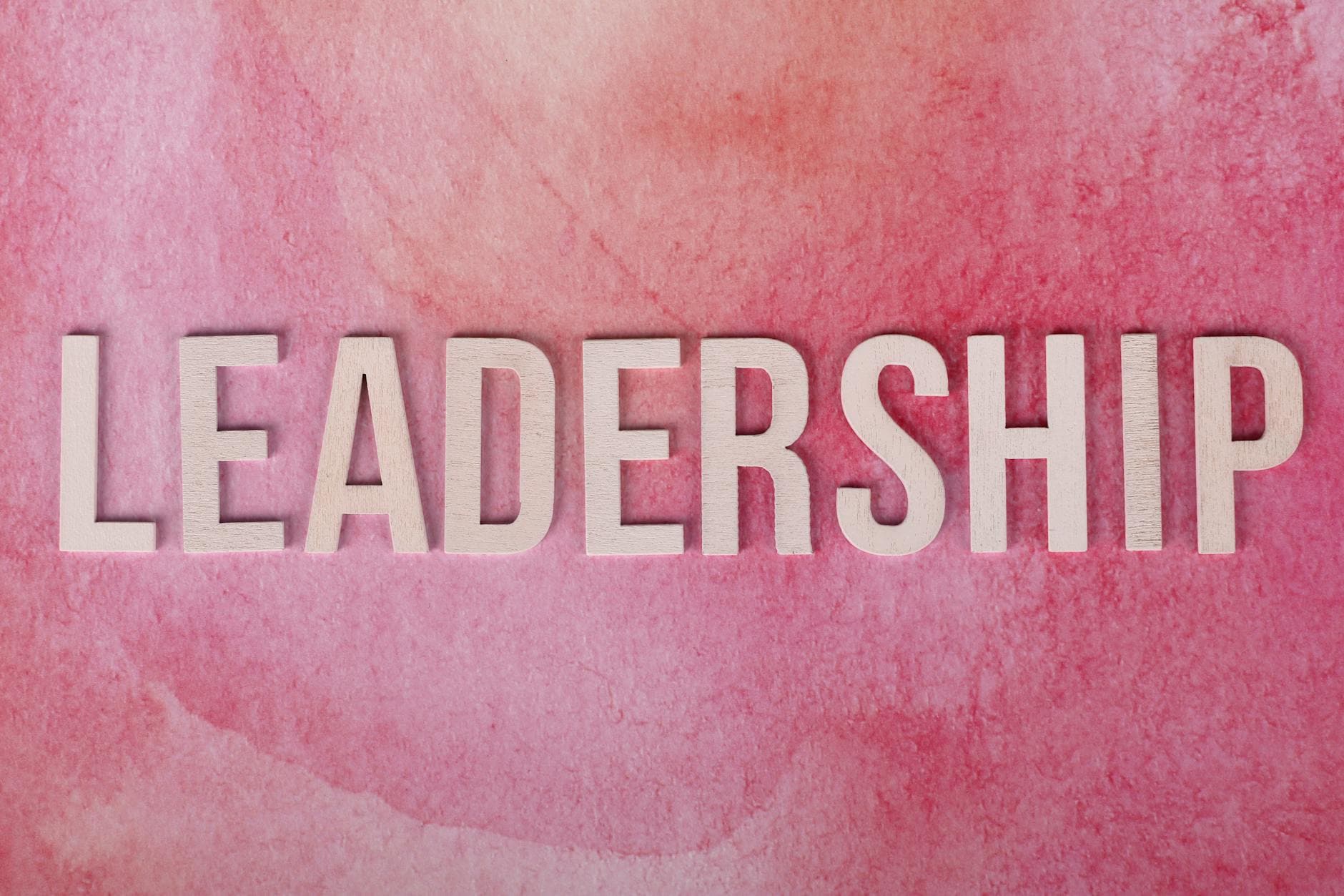 Inspirational leadership text on a vibrant pink watercolor background. - active listening examples