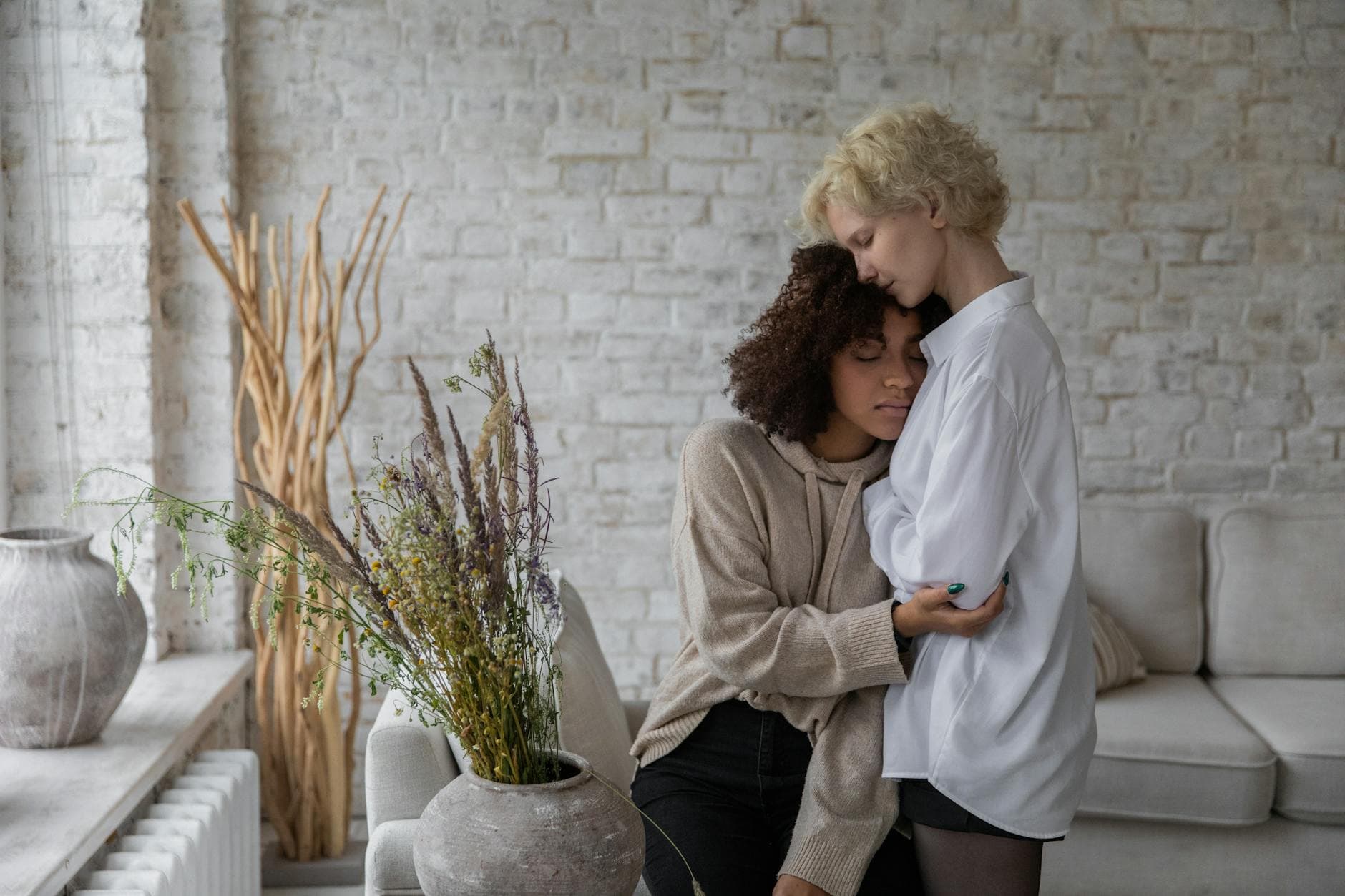 Two women enjoy a serene embrace in a cozy indoor setting. - anxious attachment style