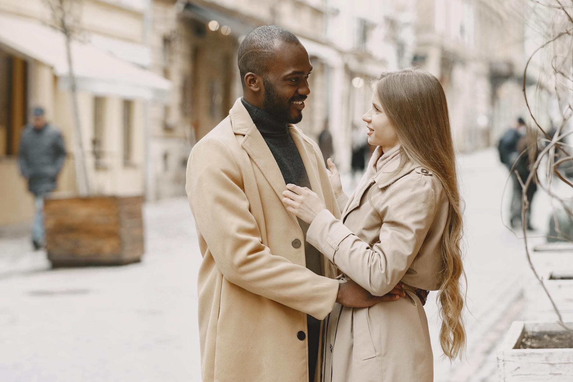 Happy interracial couple embracing outdoors in stylish winter clothing, expressing love and togetherness. - attachment style quiz
