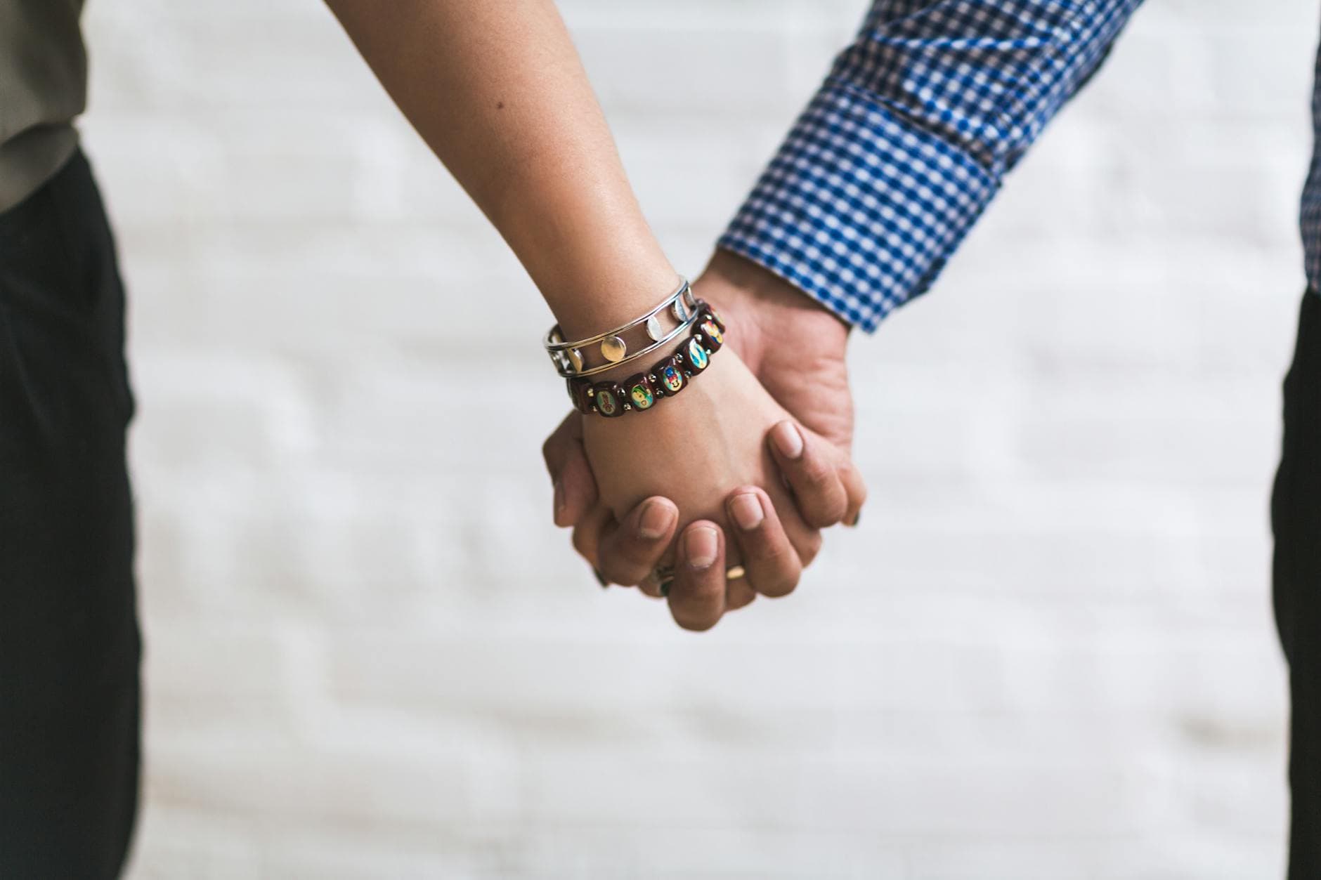 A close-up image of a couple holding hands outdoors symbolizing togetherness and unity. - build trust relationship