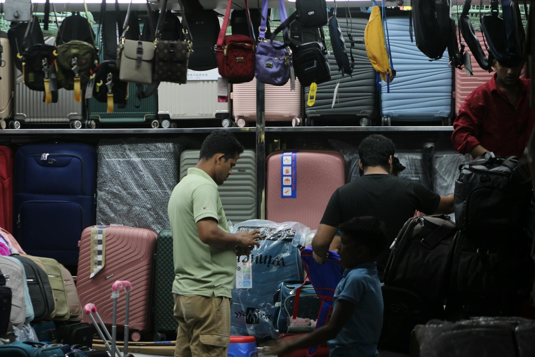 Shoppers selecting luggage and bags in a crowded store with numerous options. - declutter relationship baggage