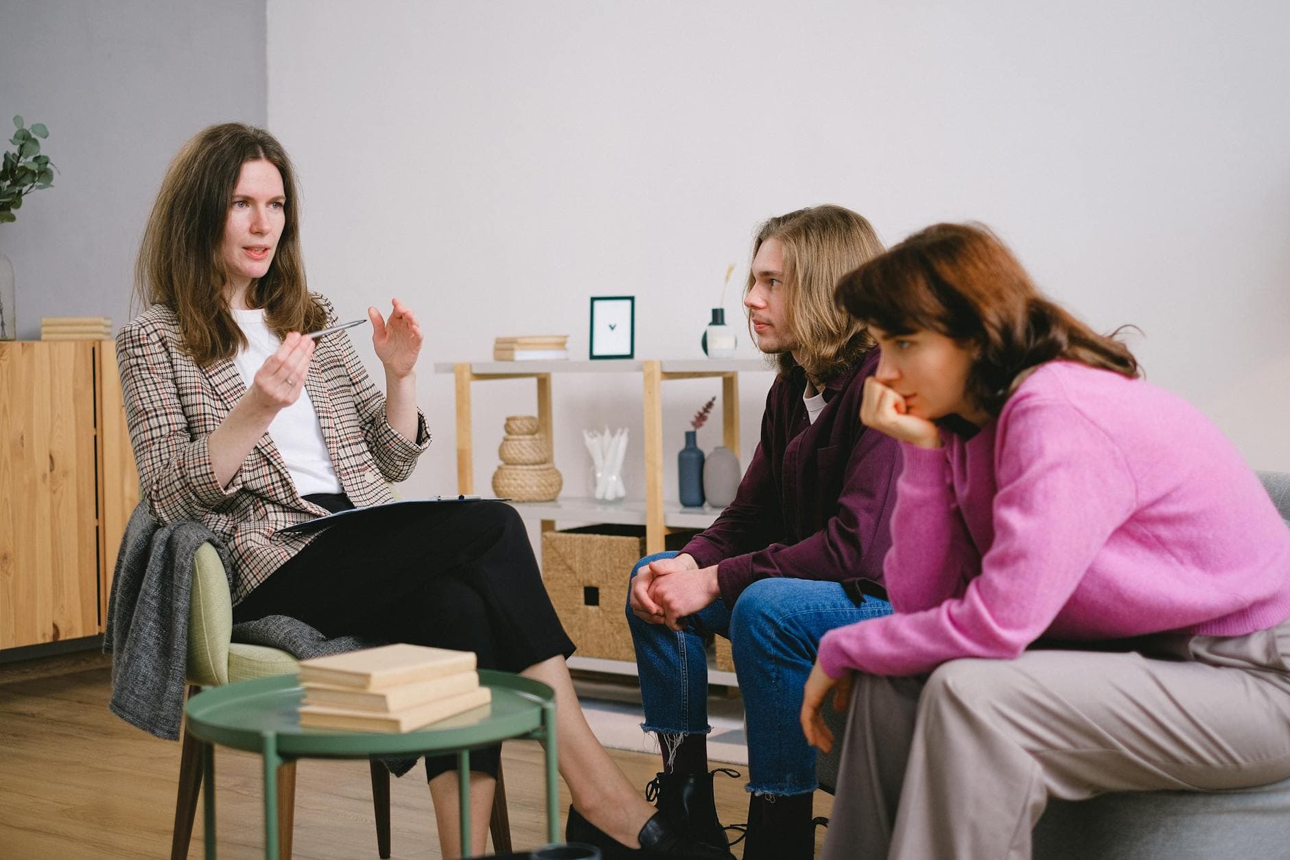 A counselor having a discussion with two students in an inviting, modern interior space. - dream analysis therapy