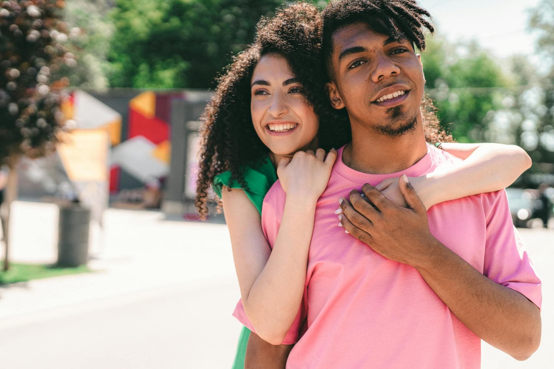 Happy interracial couple enjoying a sunny day with affectionate embrace and smiles. - express gratitude partner