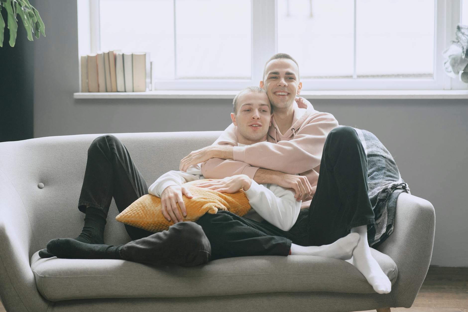 A joyful couple relaxing together on a sofa, symbolizing love and comfort in a cozy home setting. - future goals partner