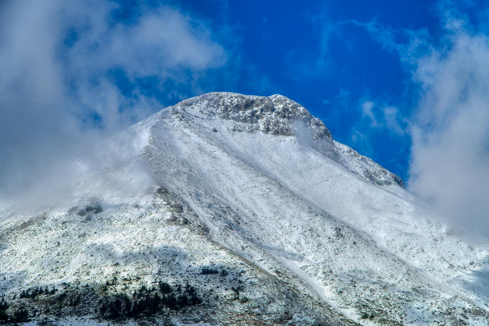 Beautiful snow-covered mountain peak with a vibrant blue sky in Greece. - kids nature exploration