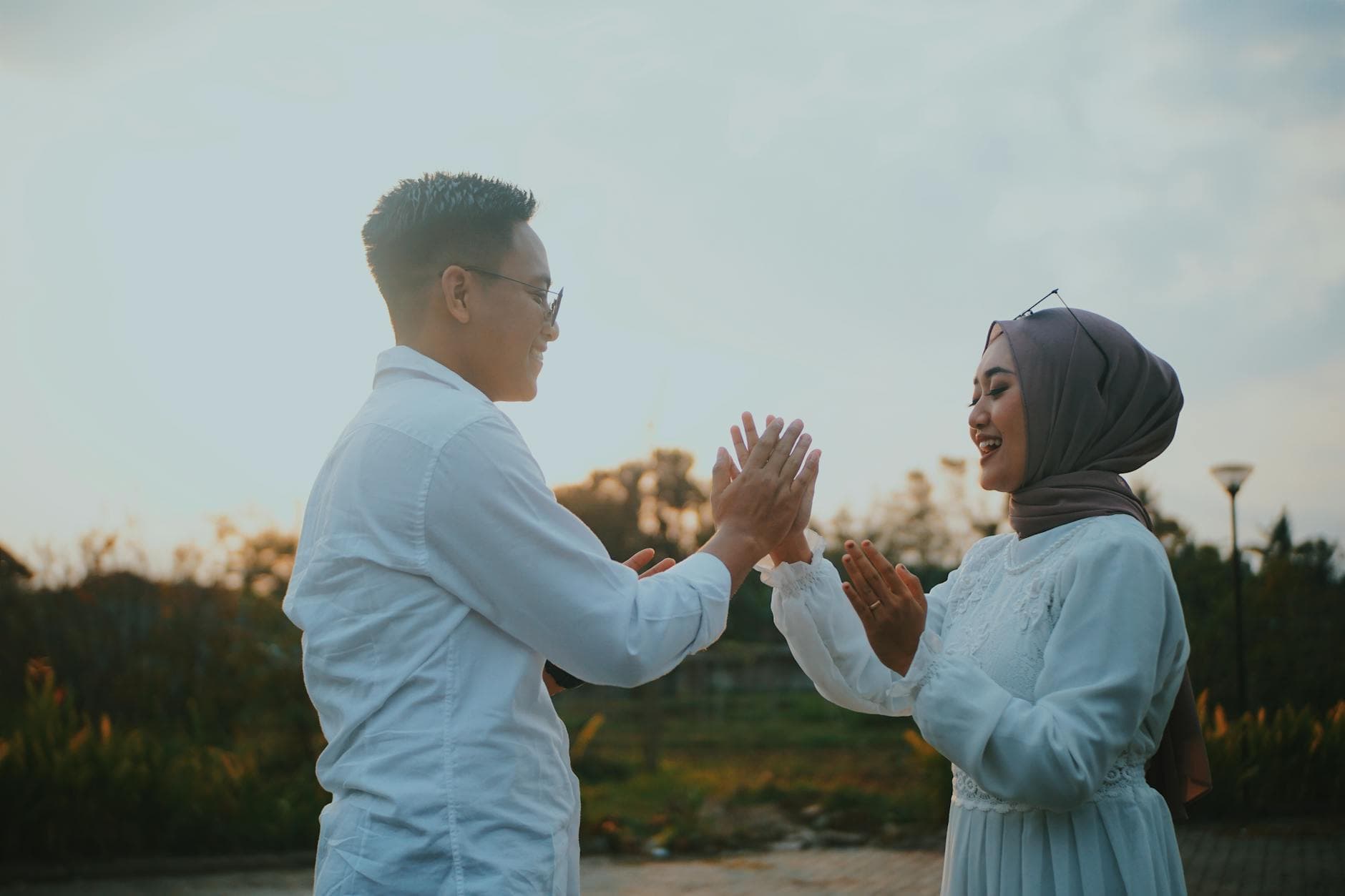 Joyful couple in traditional attire shares a playful moment outdoors at sunset, embracing love and togetherness. - marriage communication tips