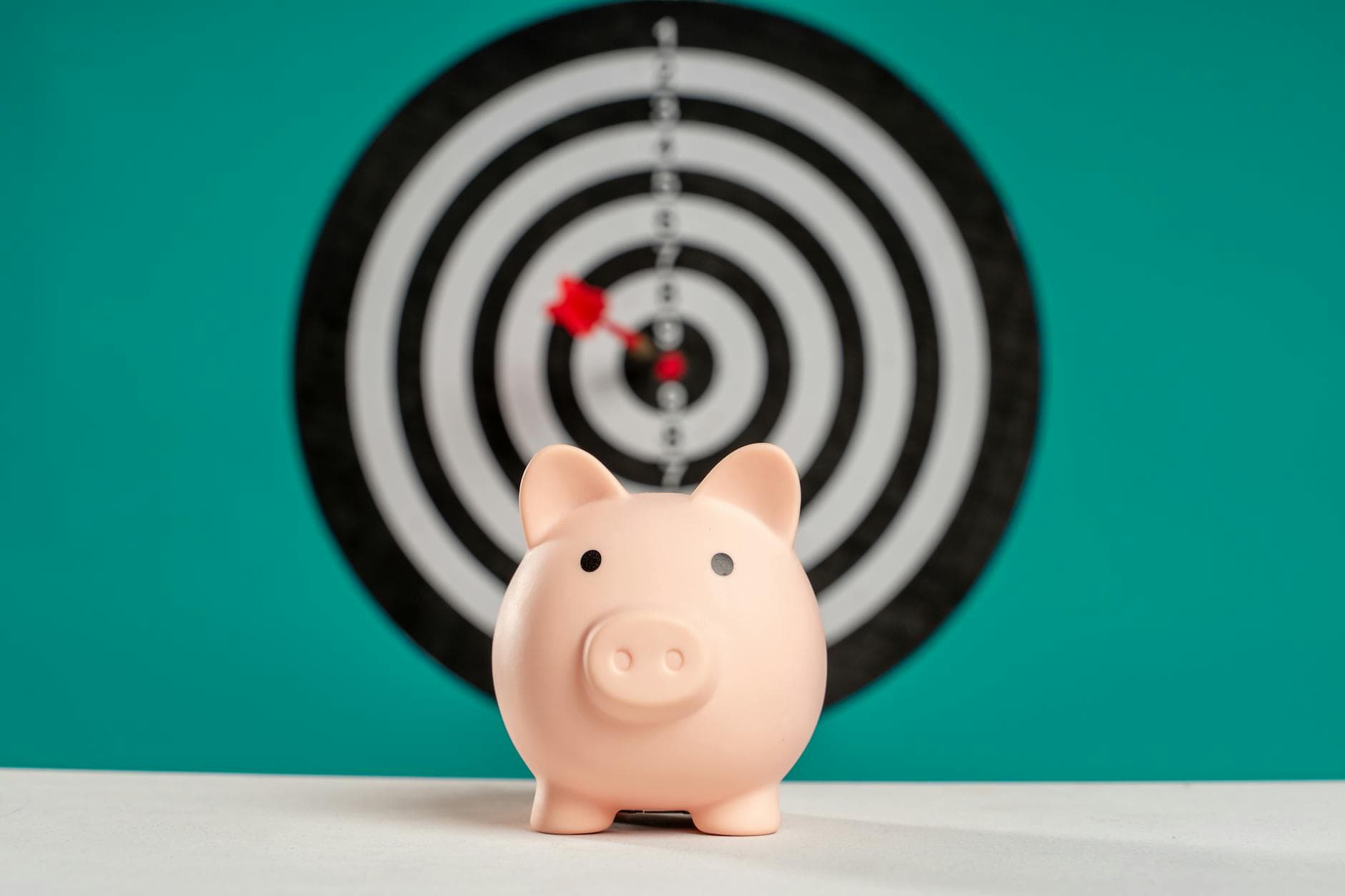 Piggy bank with bullseye dart board symbolizing financial goals and savings. - realistic personal growth goals