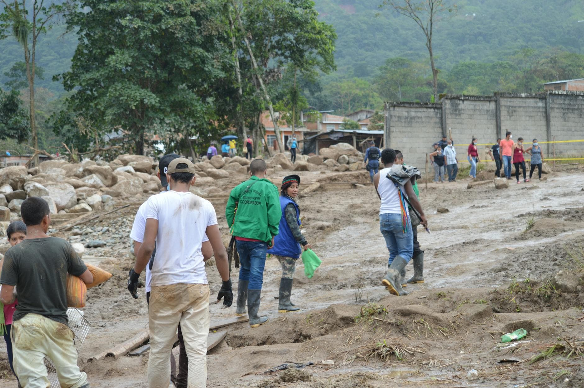 People navigate a muddy terrain in Mocoa, Colombia, post-flood recovery efforts. - rebuild trust infidelity