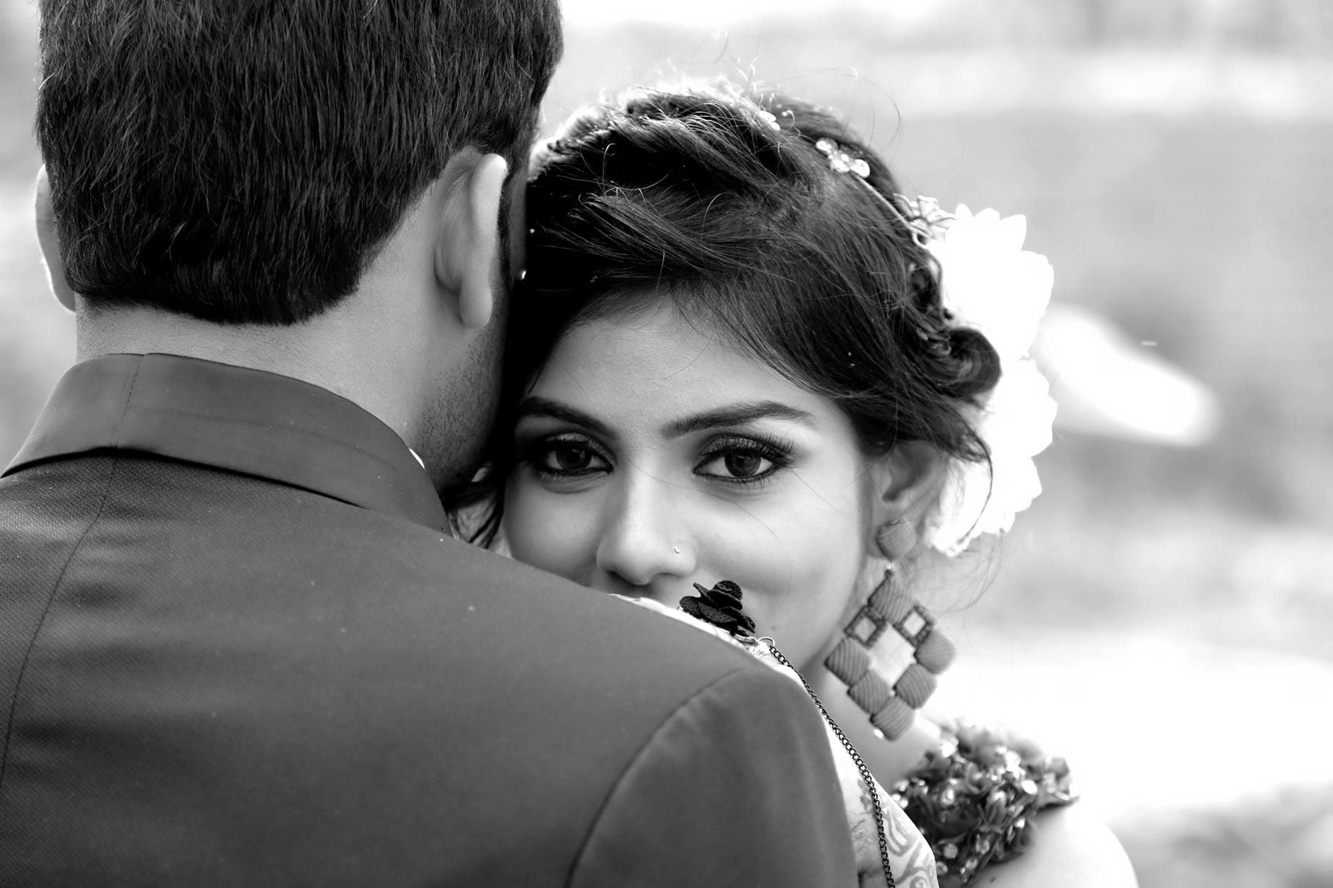 Close-up black and white portrait of a bride embracing her groom outdoors. - reconnecting with partner