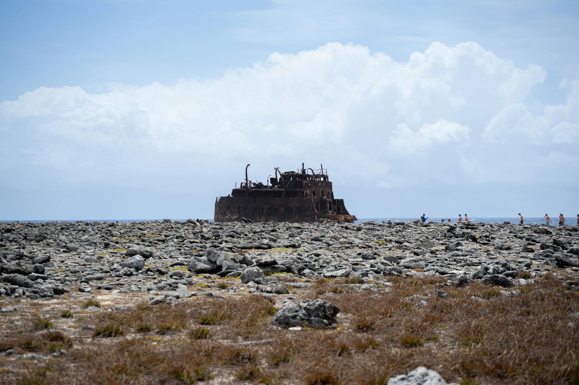Explore the haunting beauty of a rusty shipwreck on the rocky shores of Curaçao under a bright blue sky. - rekindle marital intimacy