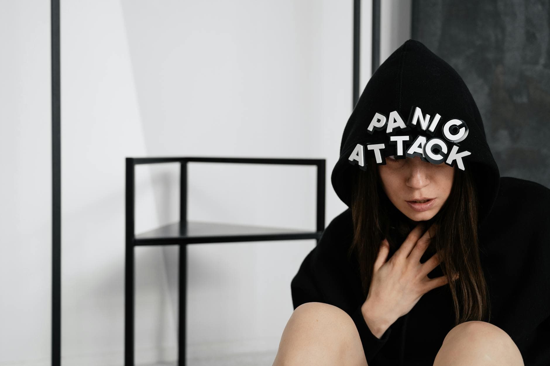 A woman in a hoodie with panic attack letters, representing mental health struggles. - spring depression help