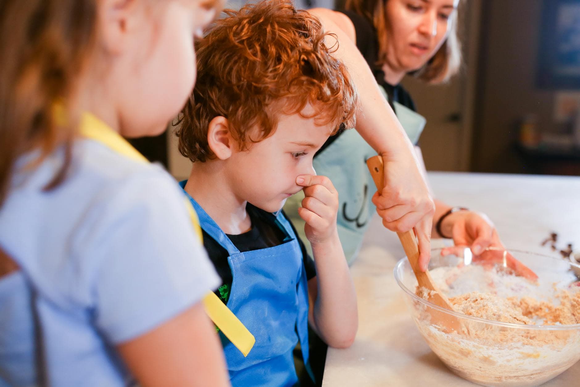 Children enjoy baking cookies with mom in a fun family cooking session. - spring parenting tips