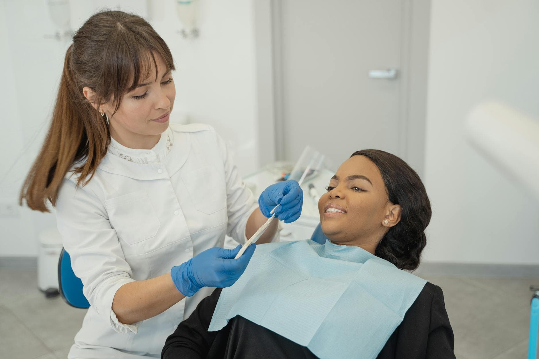A dentist provides care to a patient during a dental checkup in a clinic setting. - winter blues treatment