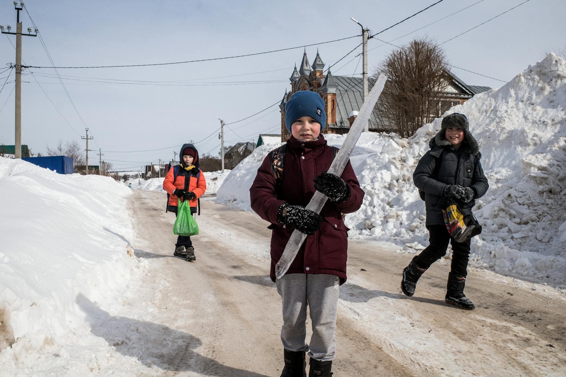Kids walking joyfully in the snow, one holding a large icicle, capturing the essence of winter fun. - winter kids activities