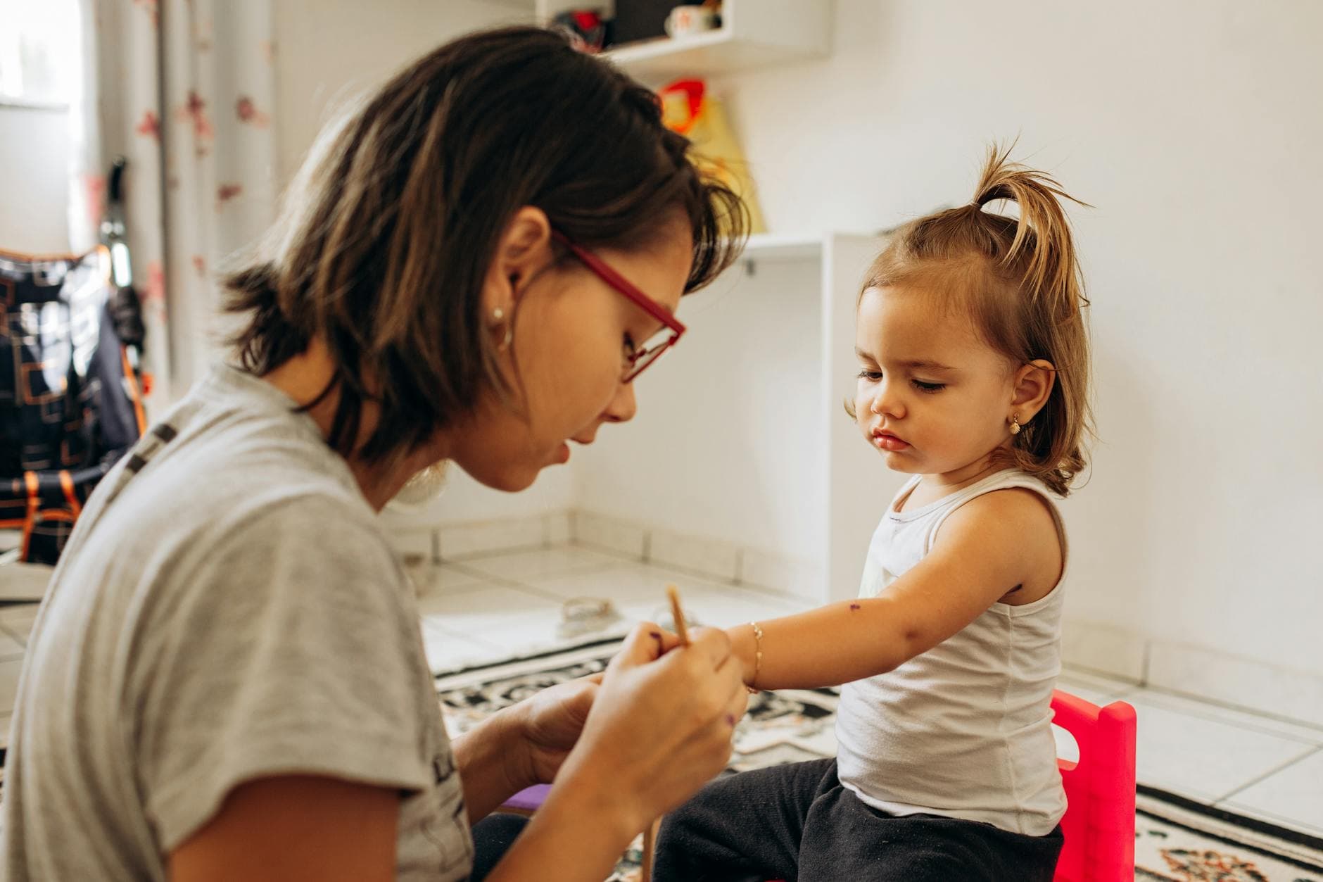 A mother and daughter bond while crafting indoors, showcasing love and creativity. - active listening toddlers