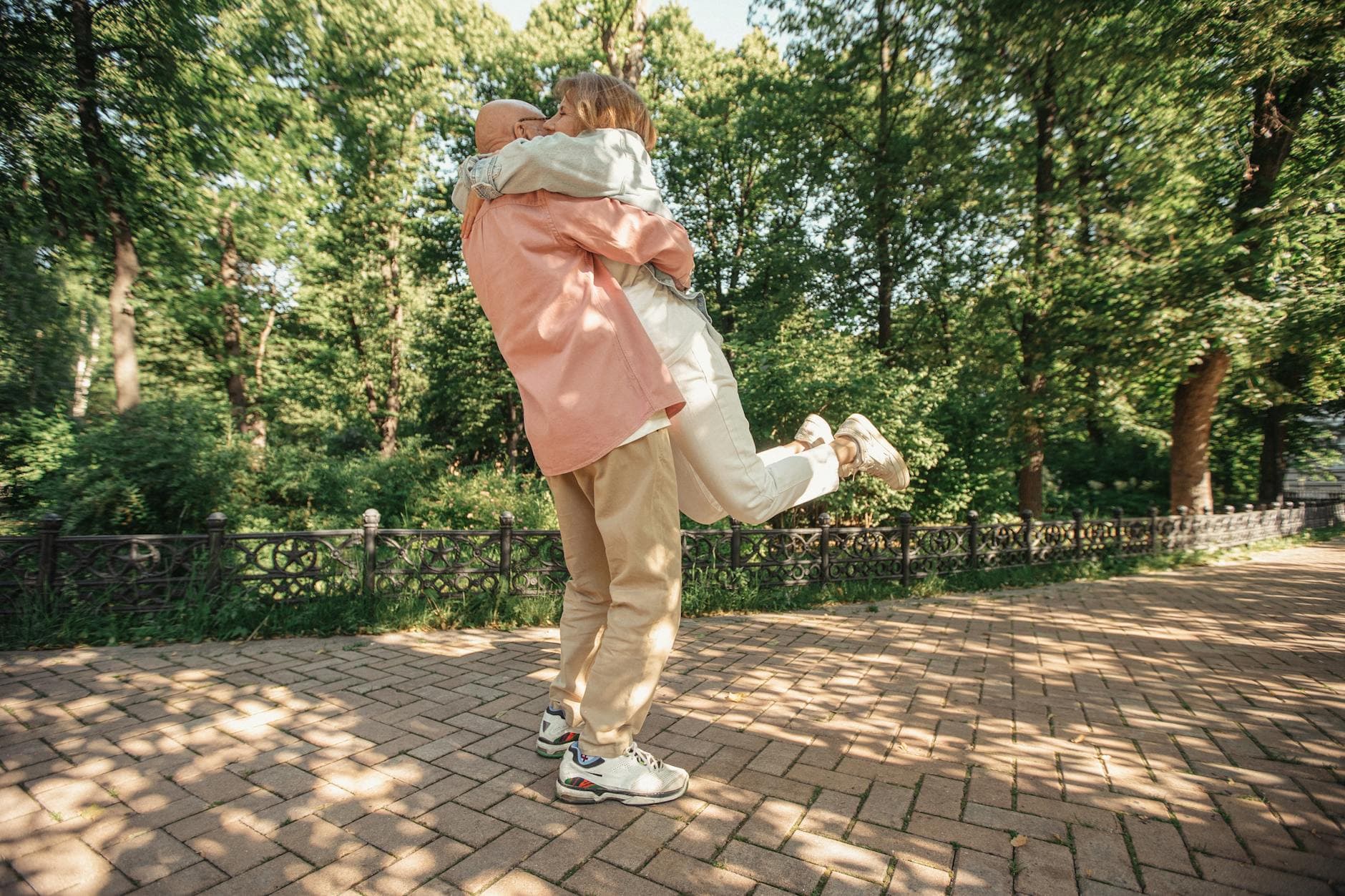 Happy senior couple embracing in a sunlit park during summer, capturing a moment of joy and love. - build trust couples