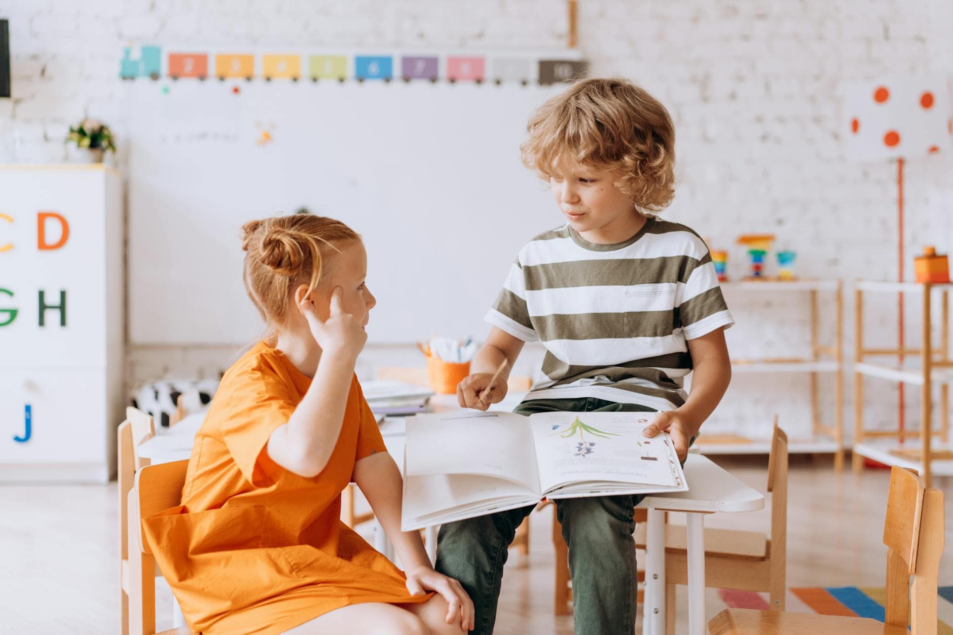 Two children engaged in reading and learning indoors at school. - child social skills