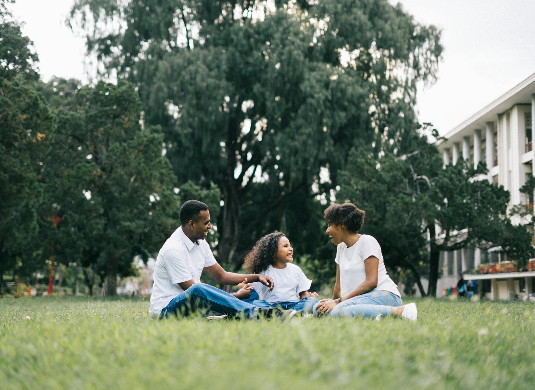 A happy black family enjoying quality time together outdoors in a lush green park. - family therapy spring