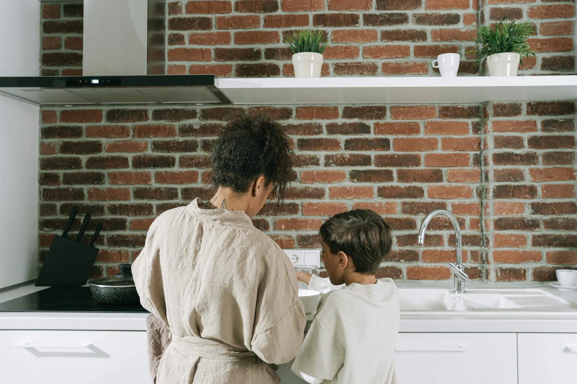 Mother and son spending quality time cooking together in a stylish kitchen setting. - fostering child independence