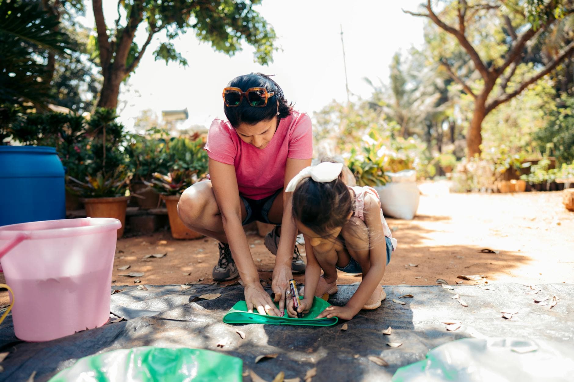 A mother and daughter bond over gardening activity in a sunny outdoor setting. - fostering independence children
