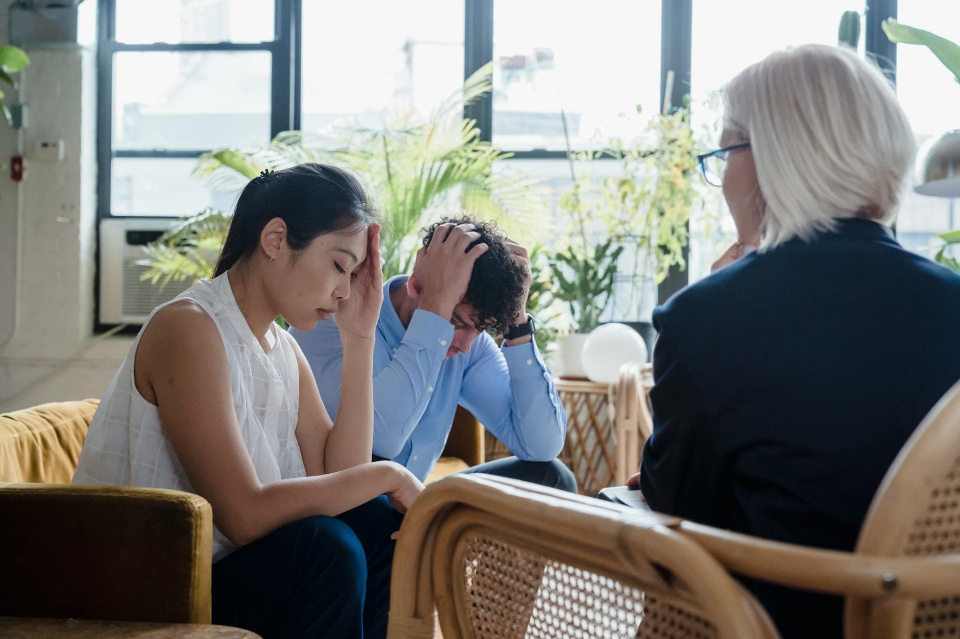 Young couple experiencing stress during a counseling session in a modern office setting. - overthinking therapy