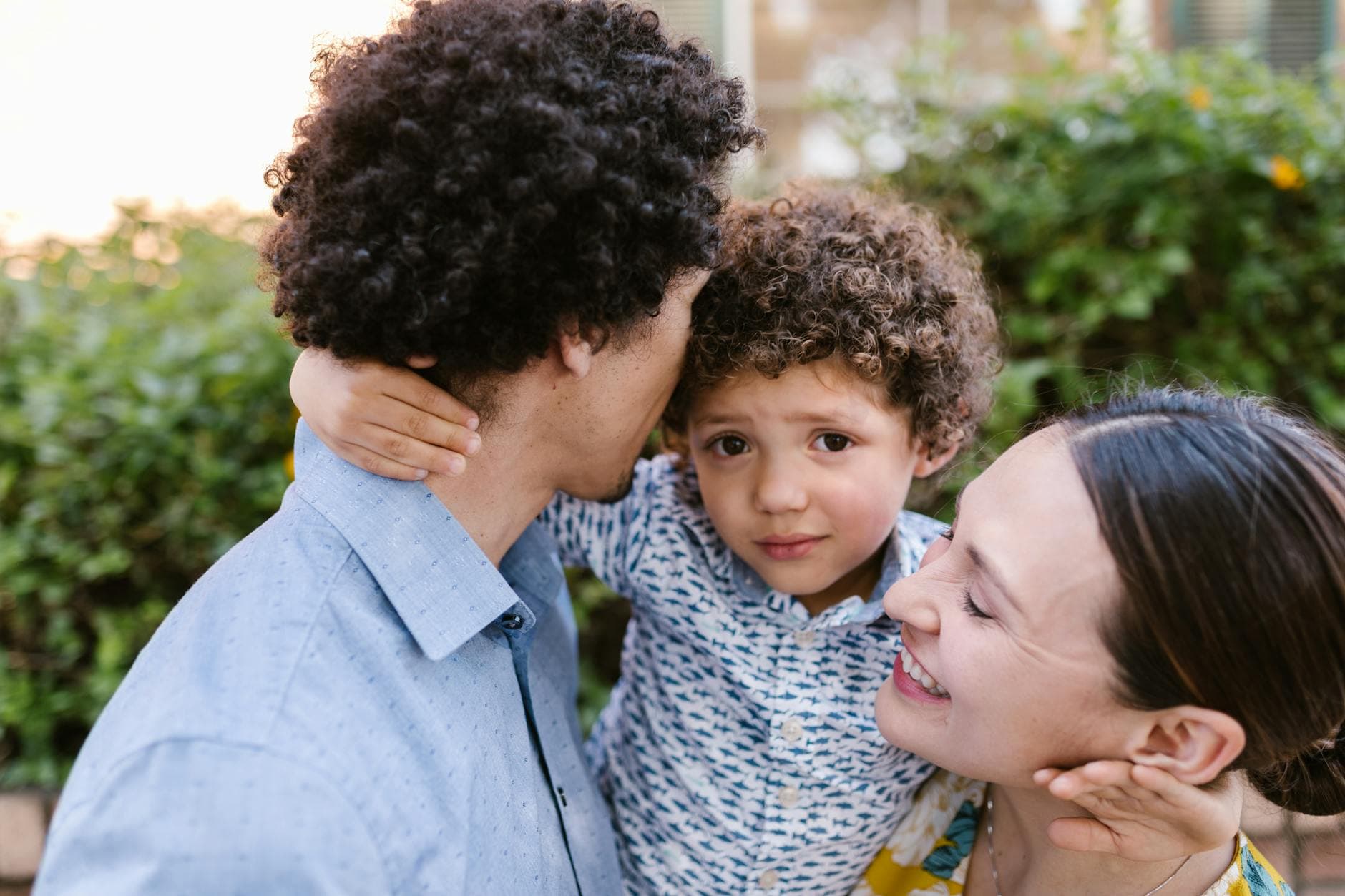 A joyful family moment captured outdoors with parents and child embracing, radiating love and happiness. - post pandemic family