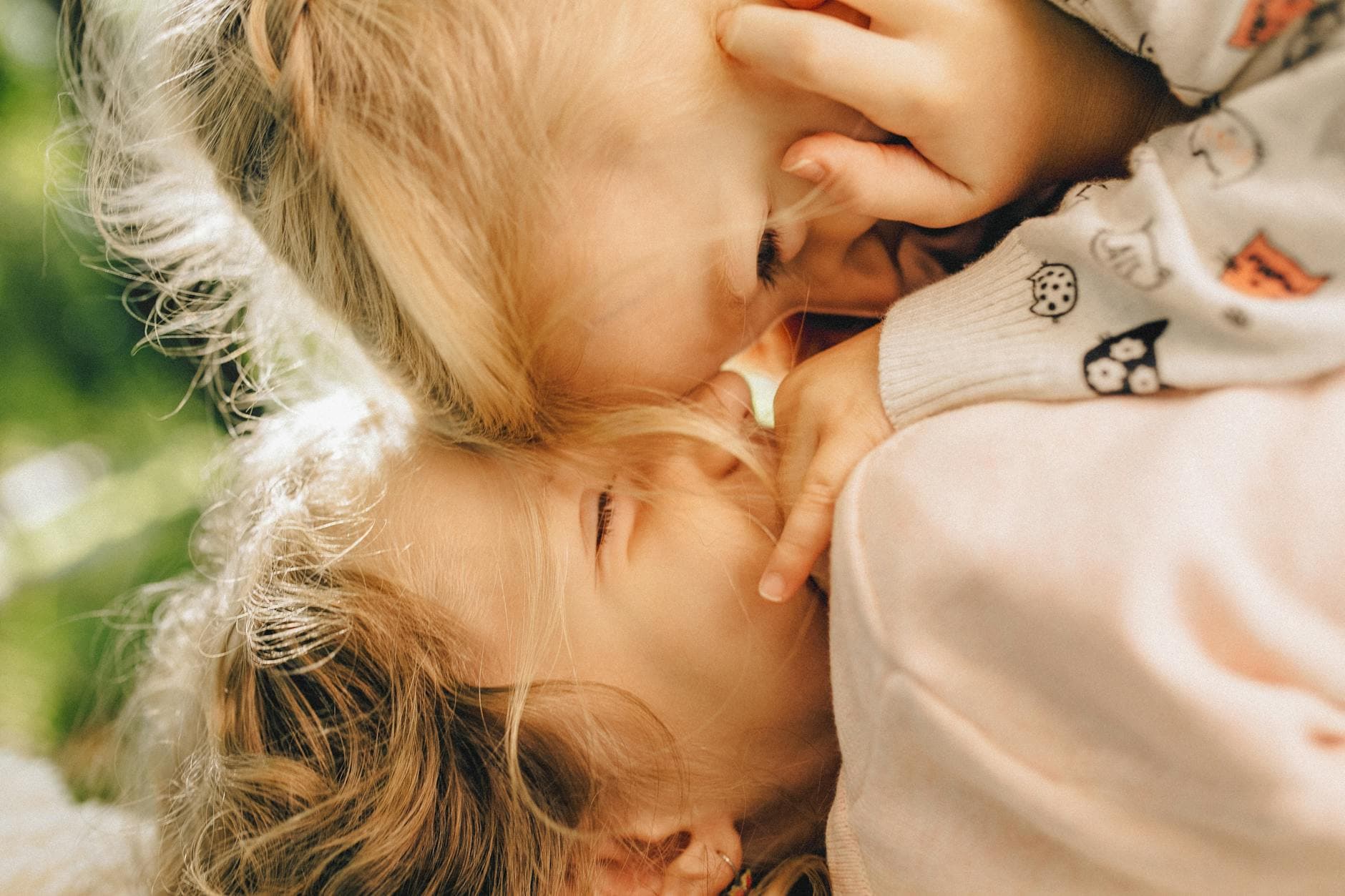 Heartwarming close-up of two blonde children playfully bonding outdoors. - sibling rivalry boston