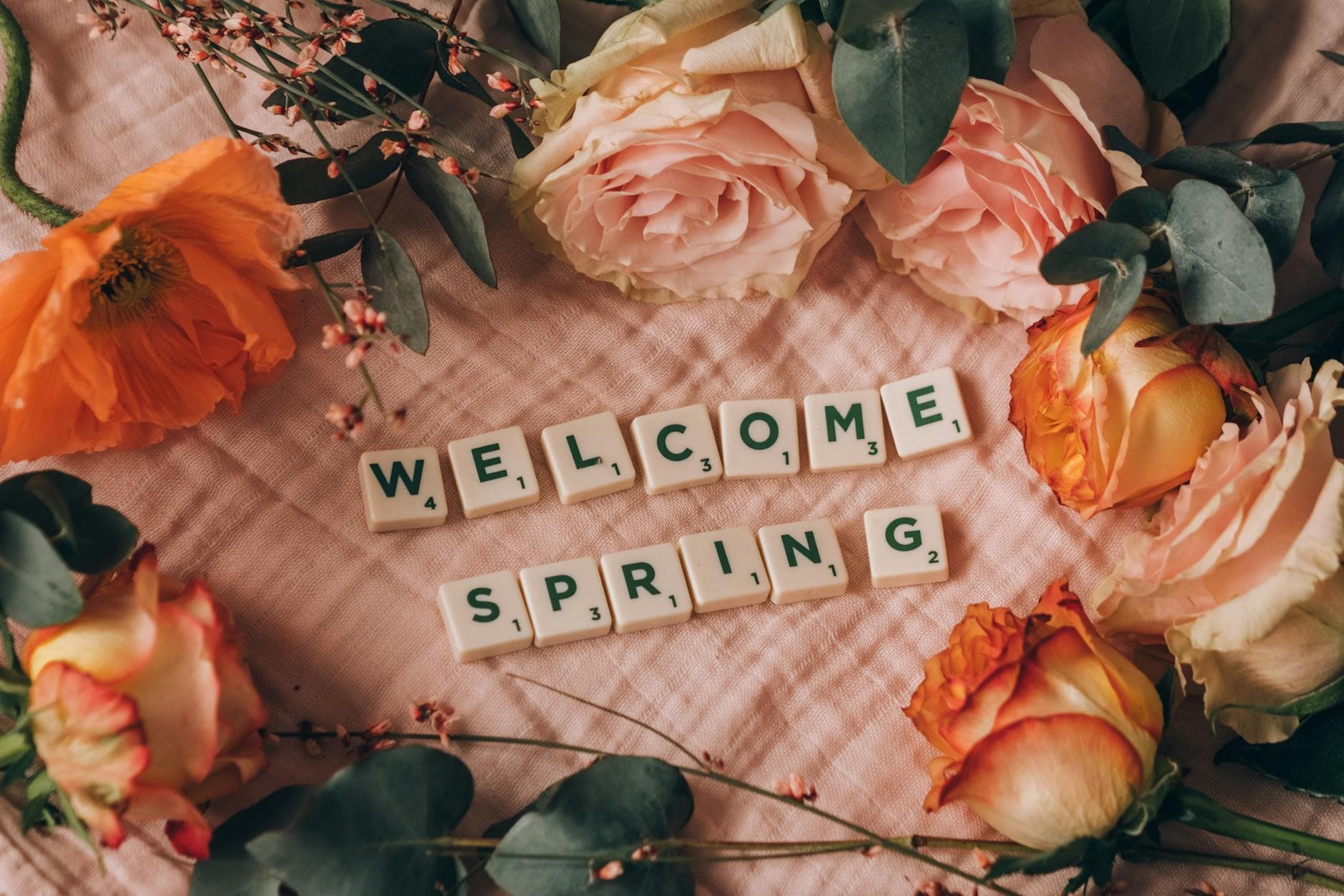 Floral arrangement with roses, eucalyptus, and welcoming message for spring using Scrabble tiles. - spring anxiety therapist