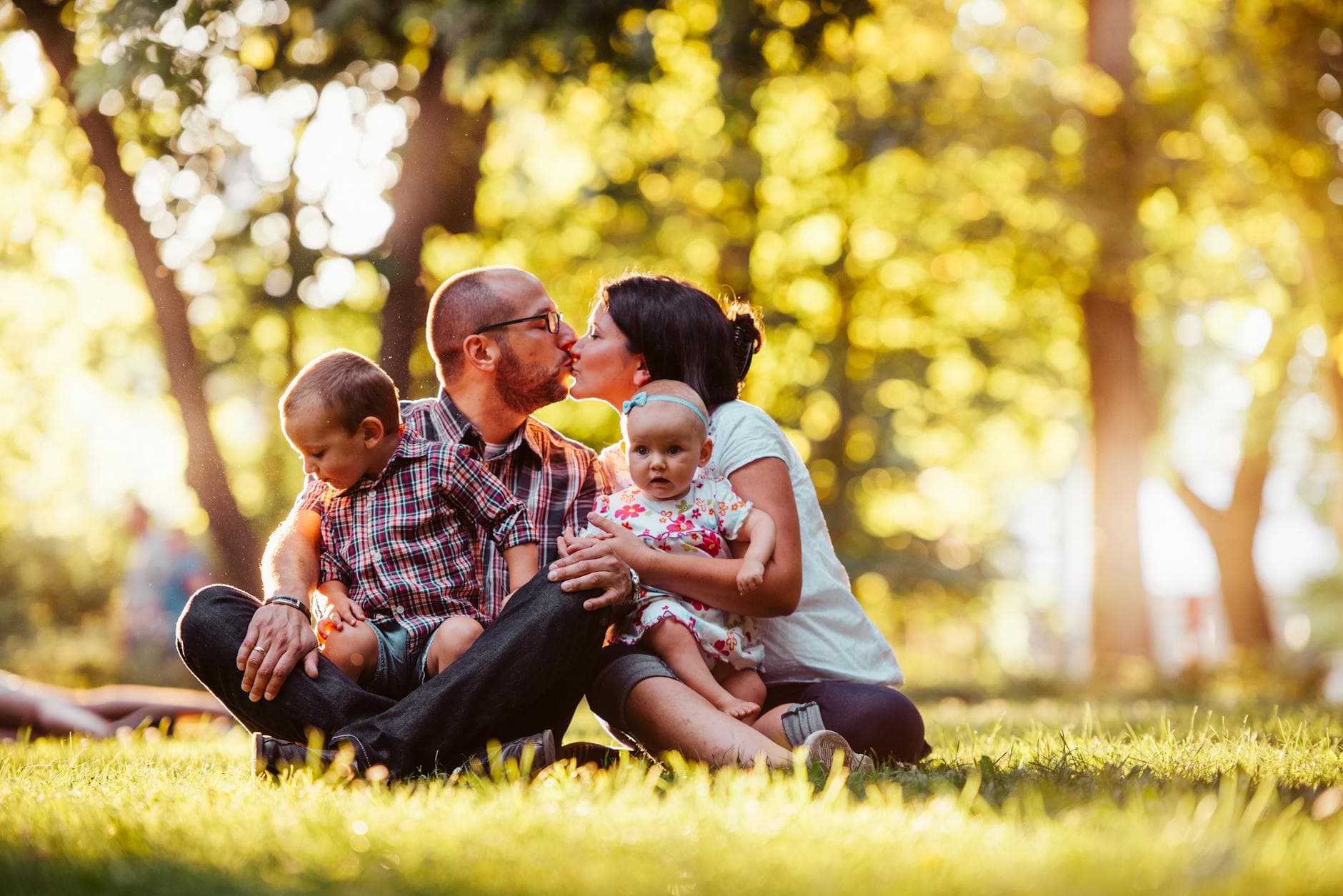 Family of four enjoying a sunny day outdoors, capturing a loving moment in nature. - blended family summer