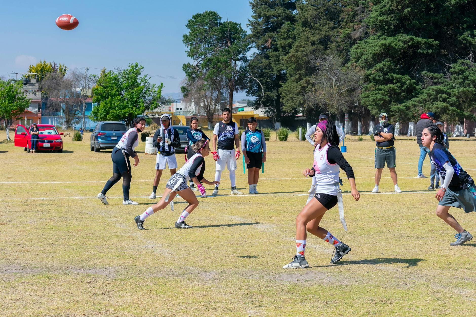 Dynamic group of teenagers playing flag football outdoors in Toluca, Mexico, showcasing teamwork and sportsmanship. - dbt skills spring