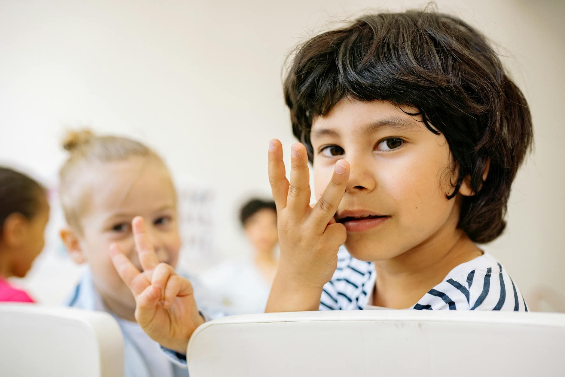 Children engaged in counting activity indoors with focus on learning and happiness. - preschooler self identity