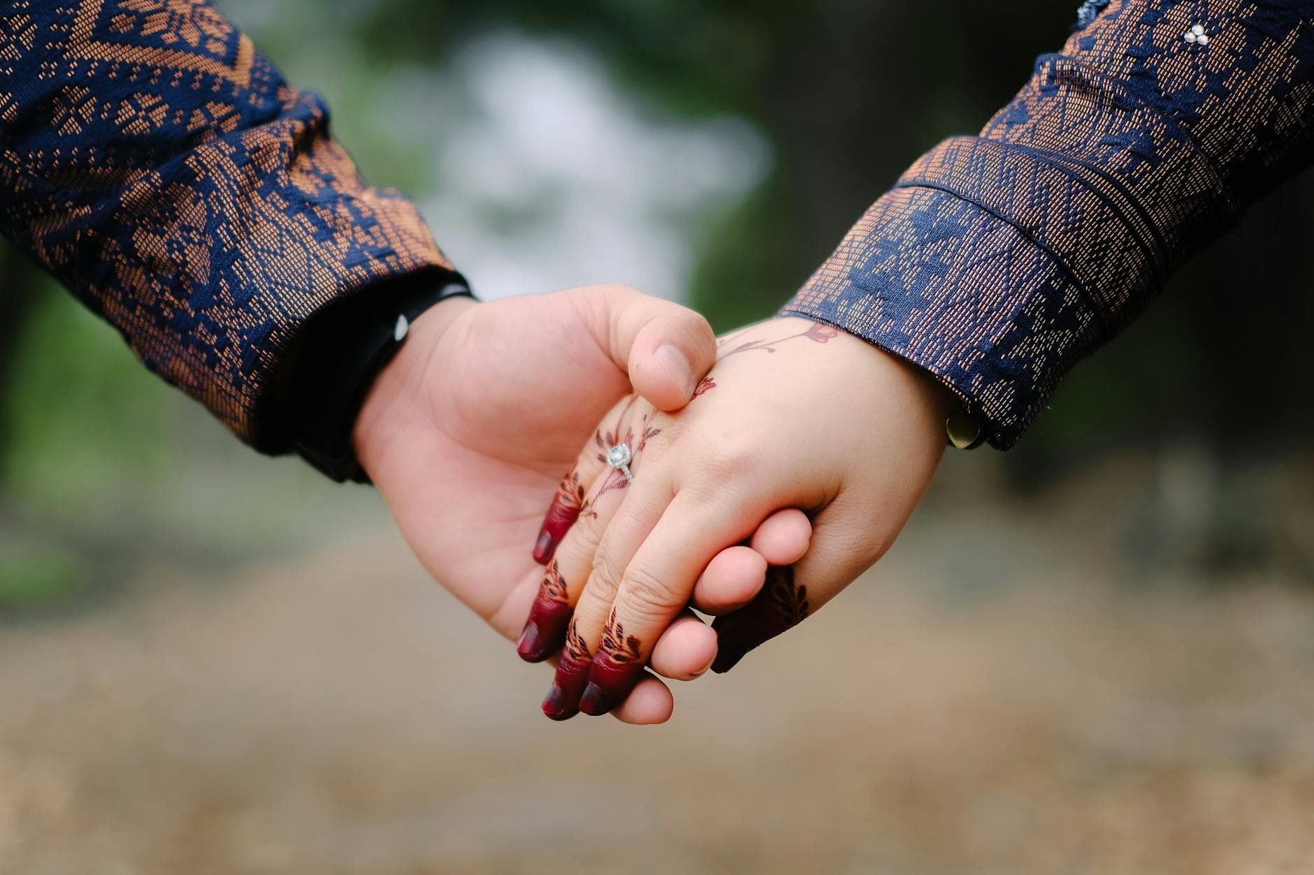 Romantic close-up of a couple holding hands with henna design outdoors. - rekindle marriage connection