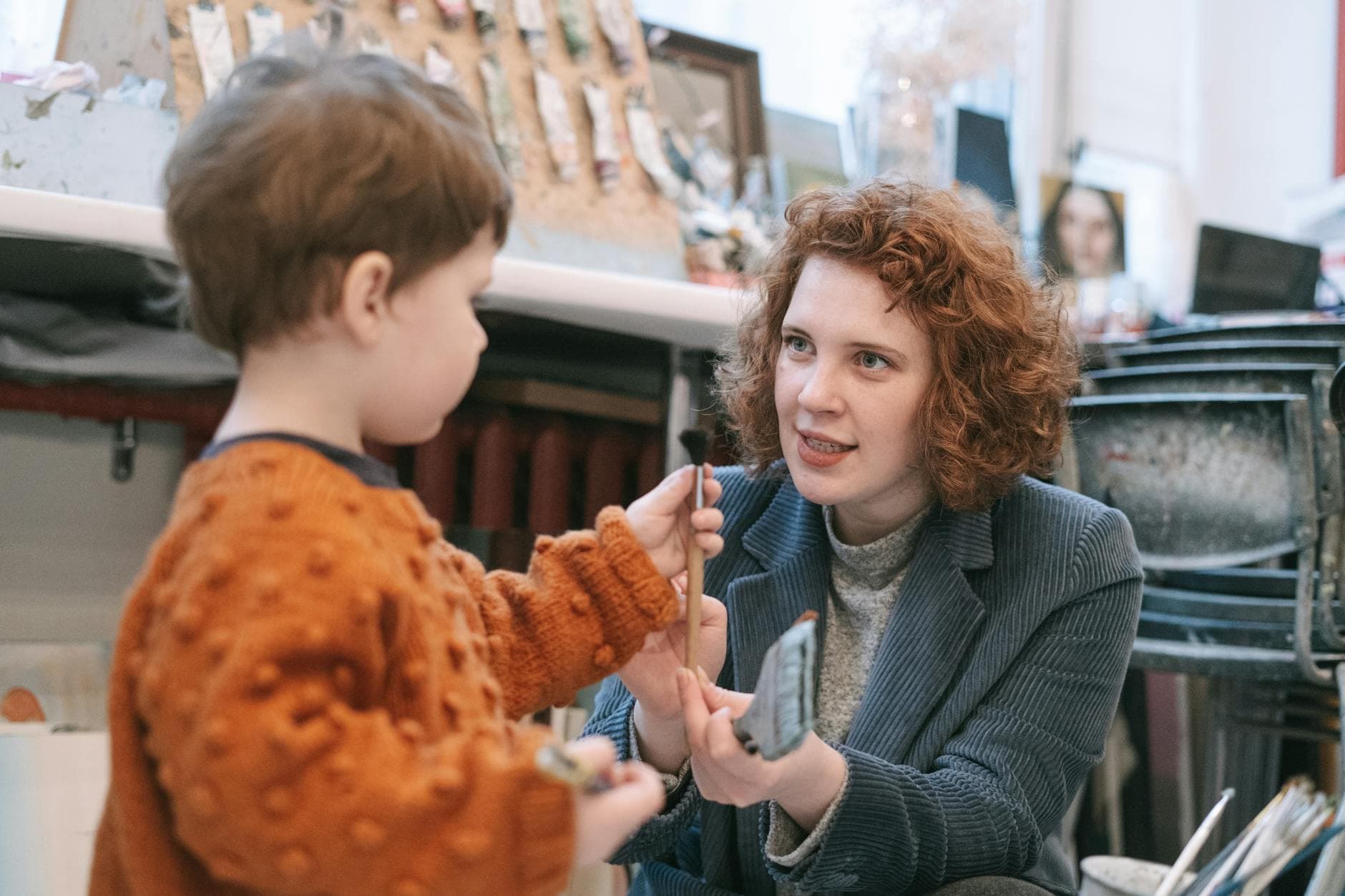 A mother and child bonding over art, sharing creativity in an indoor studio setting. - teach empathy preschoolers