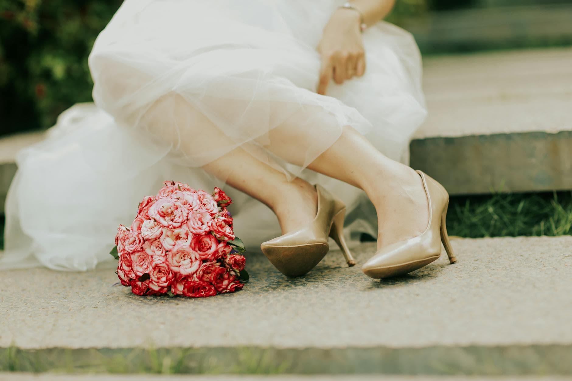 Close-up of a bride's legs, pink bouquet, and elegant heels on wedding day. - wedding stress management