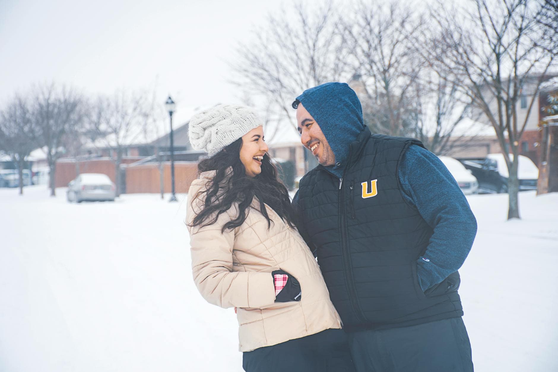 Smiling couple in winter clothing enjoying a snowy day outdoors in Dallas, Texas. - cold weather couple communication
