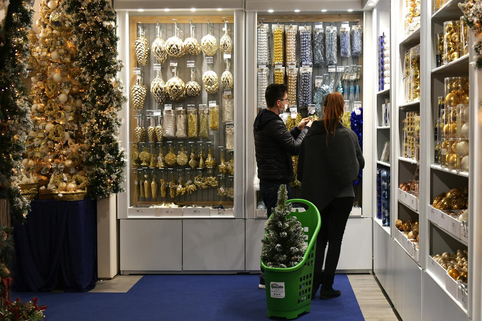 Couple shopping for Christmas ornaments in a festive store setting. - couples therapy holiday season