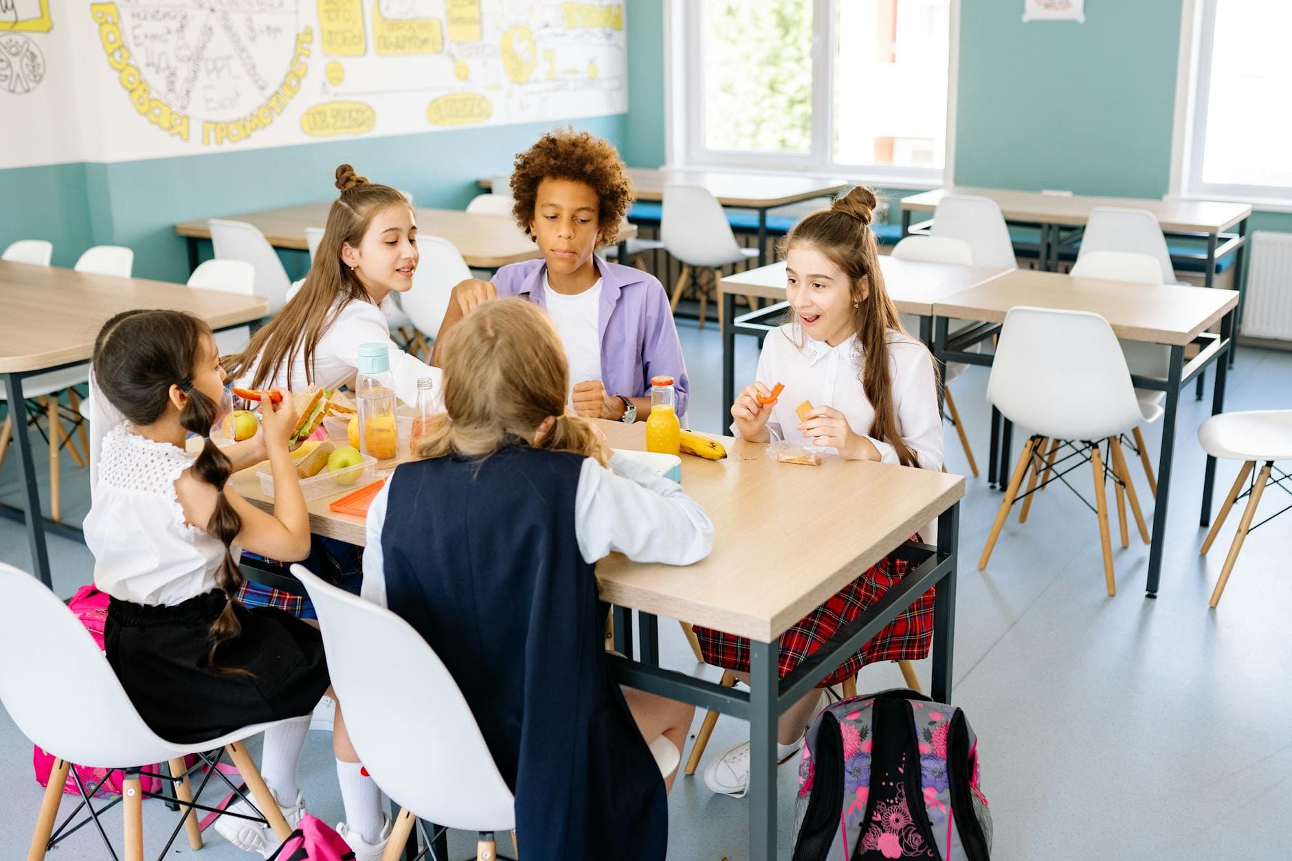 A diverse group of school children enjoying lunch together in a canteen. - february school break parenting