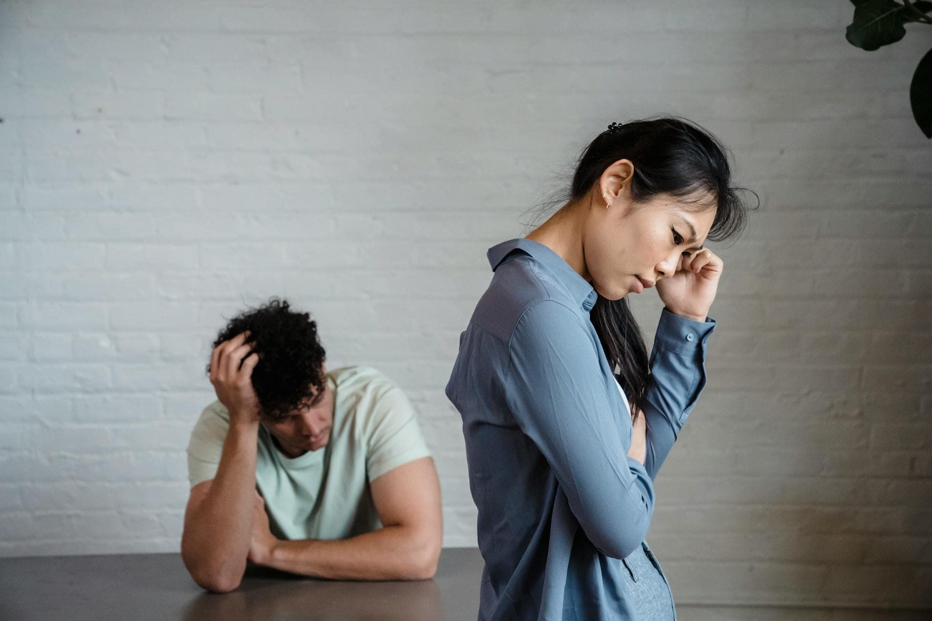 An Asian woman and man feeling misunderstood and frustrated in a relationship indoors. - relationship conflict resolution