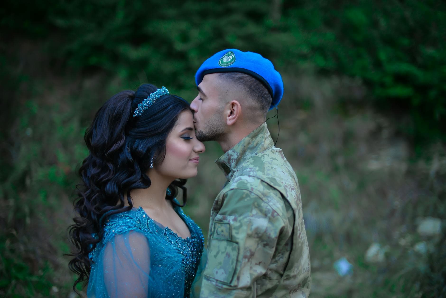 A soldier in camouflage kisses a woman in a blue dress, symbolizing love and military life. - support partner winter blues