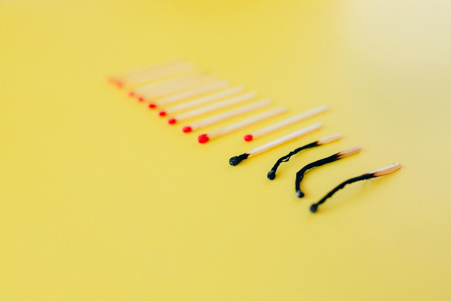 Symbolic representation of burnout using matches on a yellow background, illustrating exhaustion. - winter burnout strategies