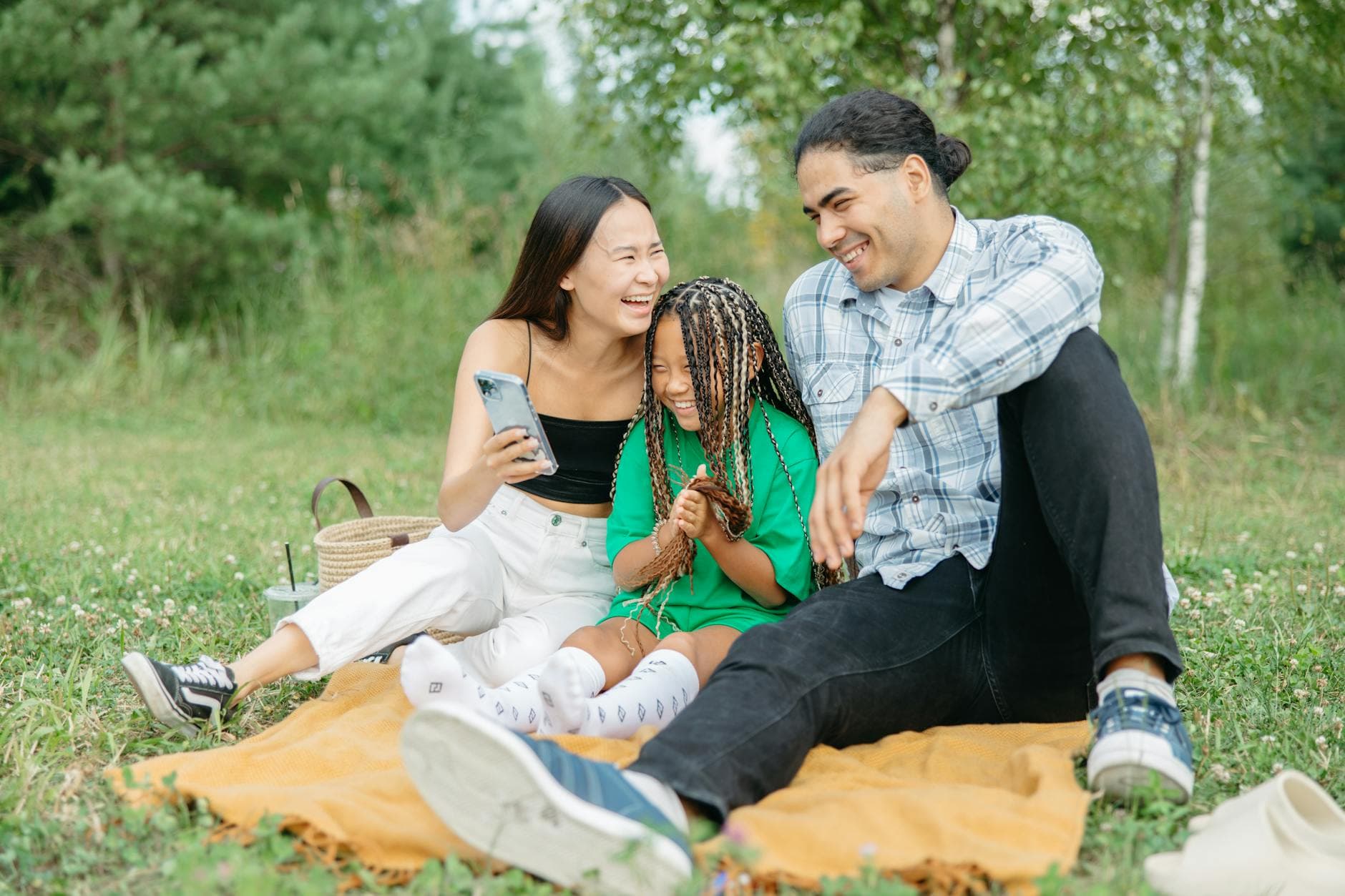A joyful family enjoying a picnic together, capturing a moment of happiness and unity in a serene park setting. - blended family spring holidays