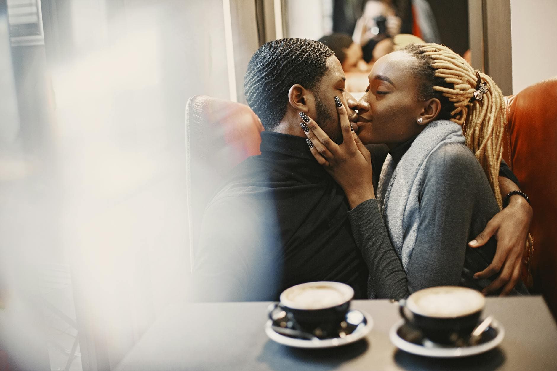An affectionate couple sharing an intimate moment in a cozy café setting. - dating tips introverts