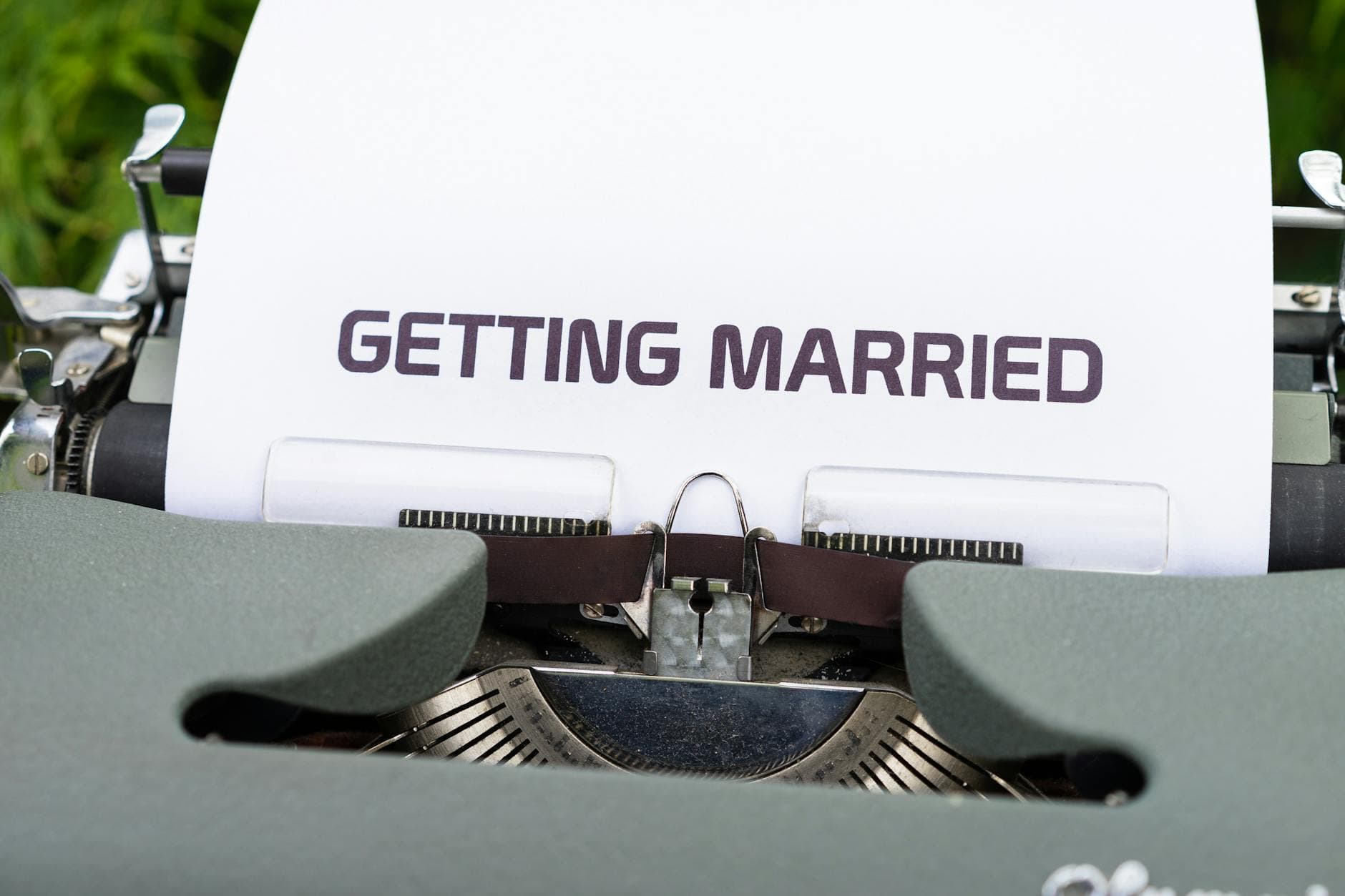Close-up of a vintage typewriter with 'Getting Married' typed on paper, symbolizing romance. - express needs marriage